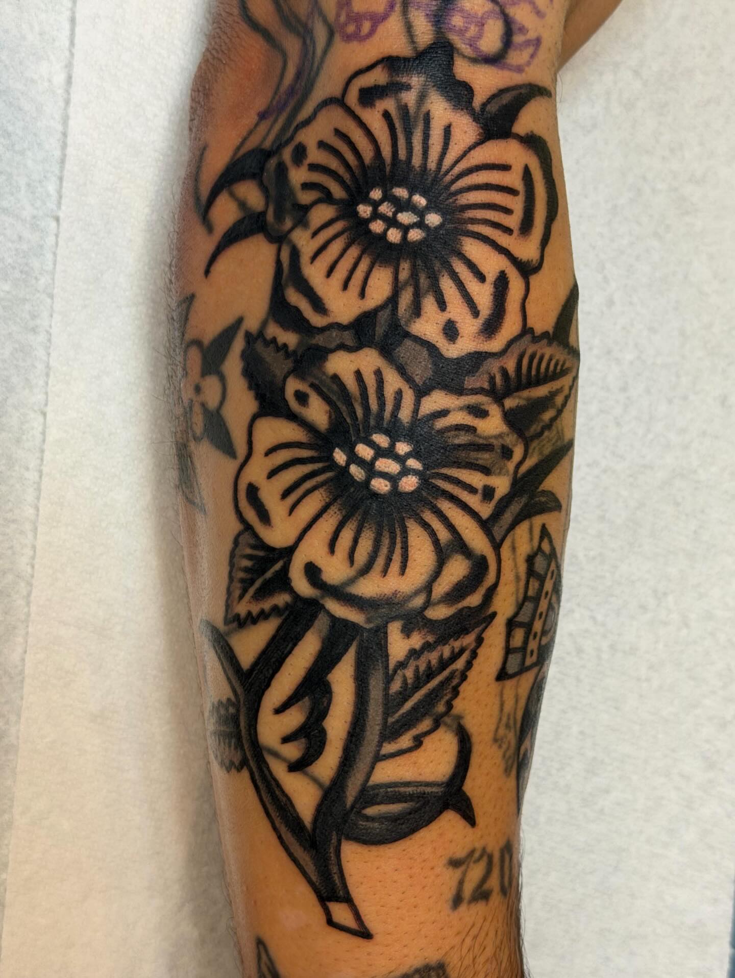 Flowers black and grey tattoo on the forearm by Jake