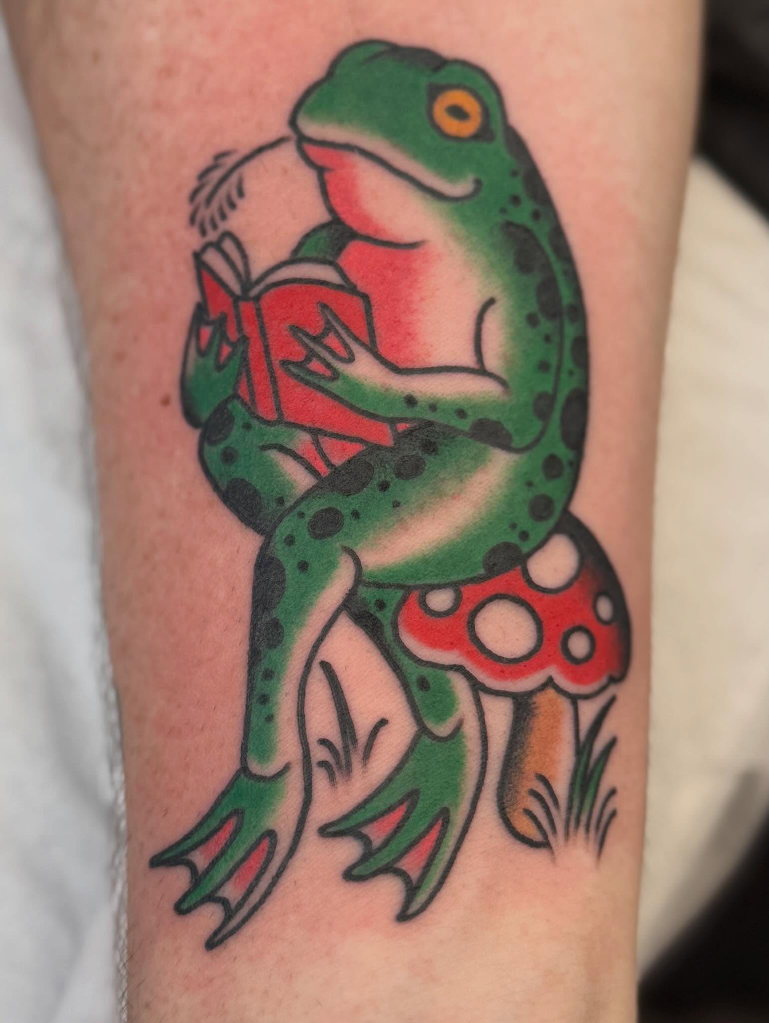 Frog reading book American traditional tattoo on the forearm by Chase Martines