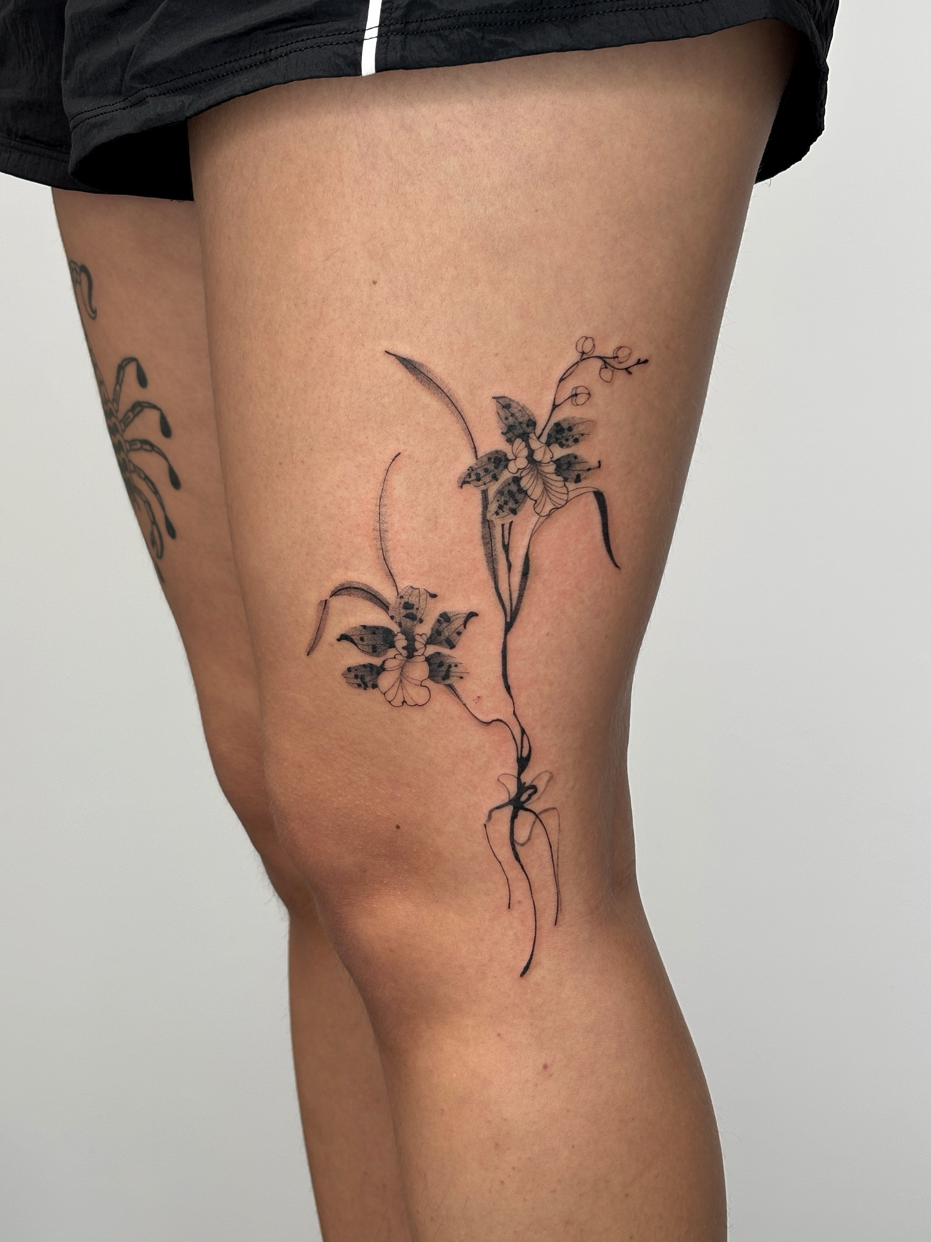 Flower black and grey tattoo on the thigh by sago, Berkeley, California
