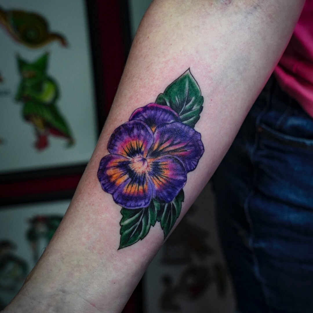 Purple pansy realism tattoo on the forearm by Spicoli