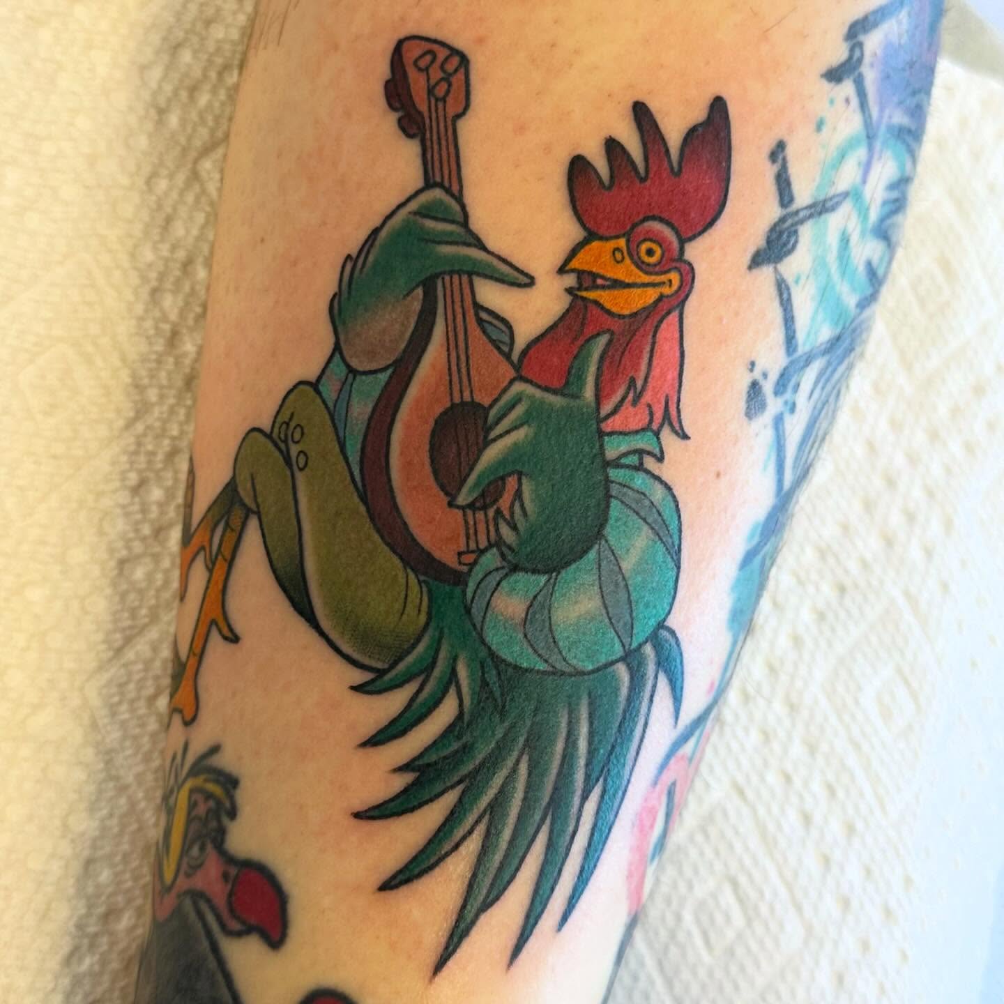 Rooster playing guitar American traditional tattoo on the forearm by Katie Beth