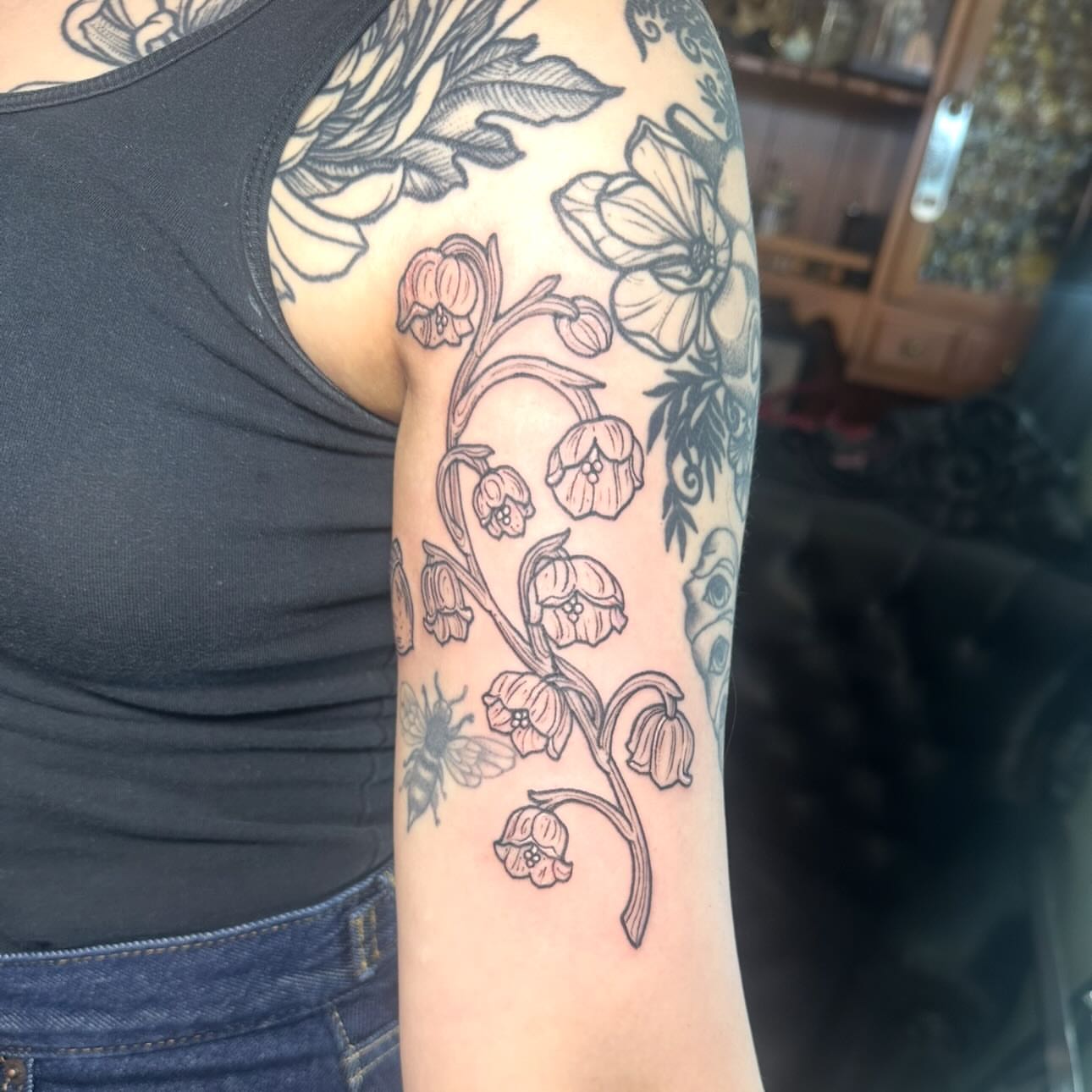 Lily of the valley black and grey tattoo on the forearm by Leeuh Vandever