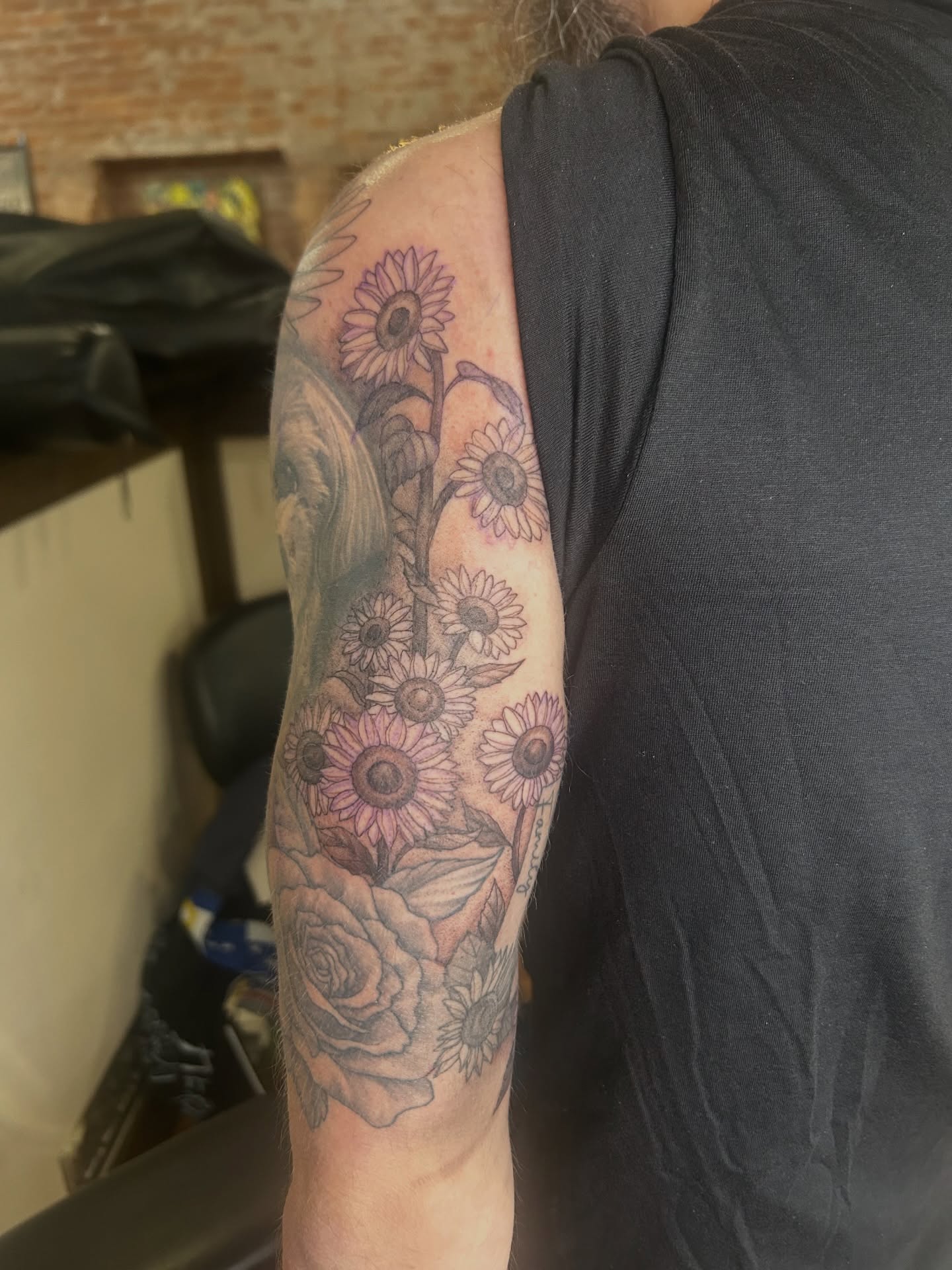 Sunflowers and roses black and grey tattoo on the upper arm by Kaylee