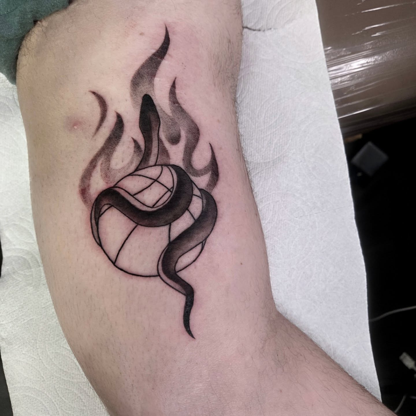 Volleyball with snake and flames geometric tattoo on the forearm by Yvette Cebreros