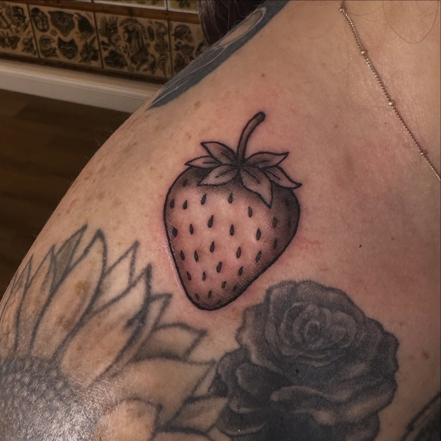 Strawberry black and grey tattoo on the shoulder by Drew’s Tattoos (NH)