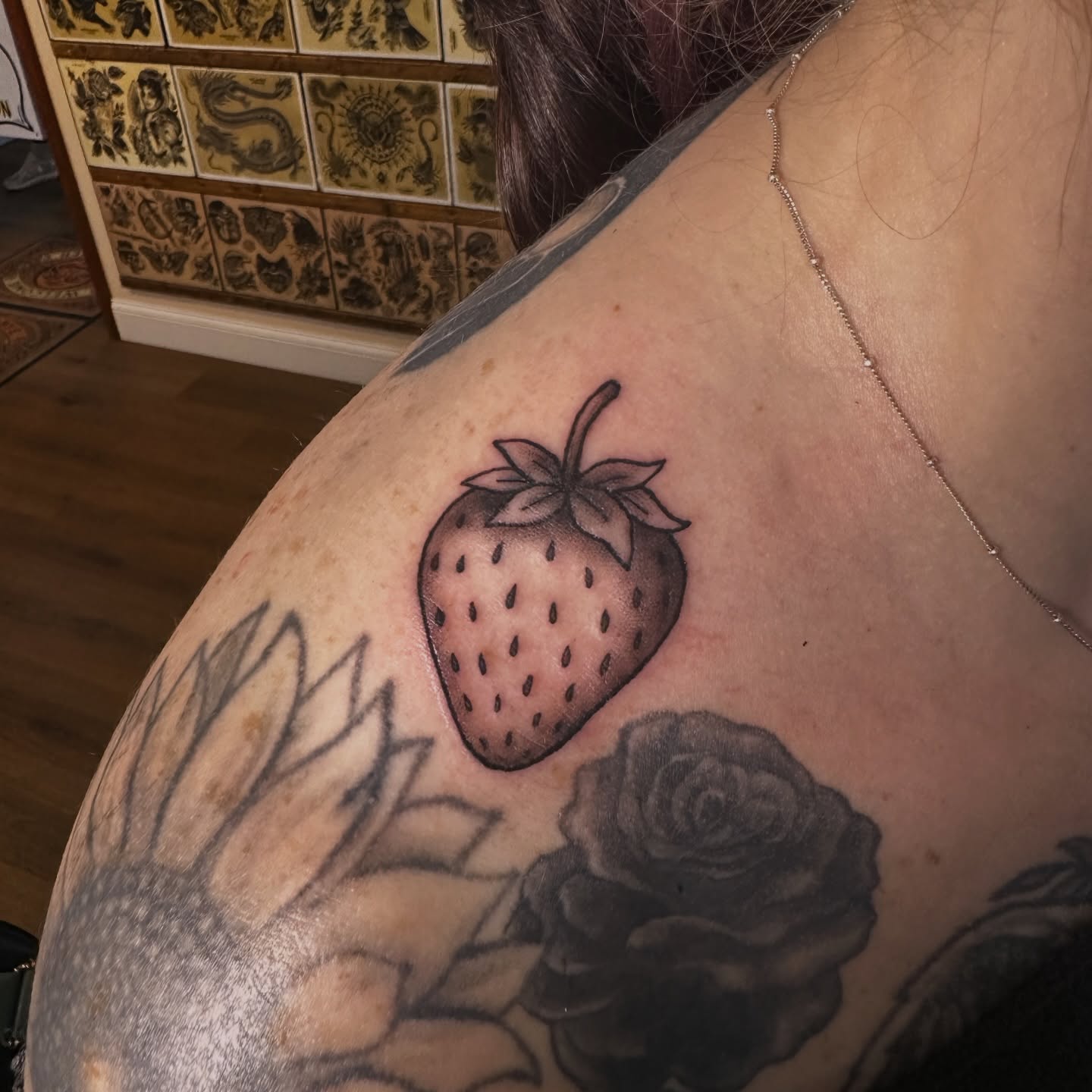 Strawberry black and grey tattoo on the shoulder by Drew’s Tattoos (NH)
