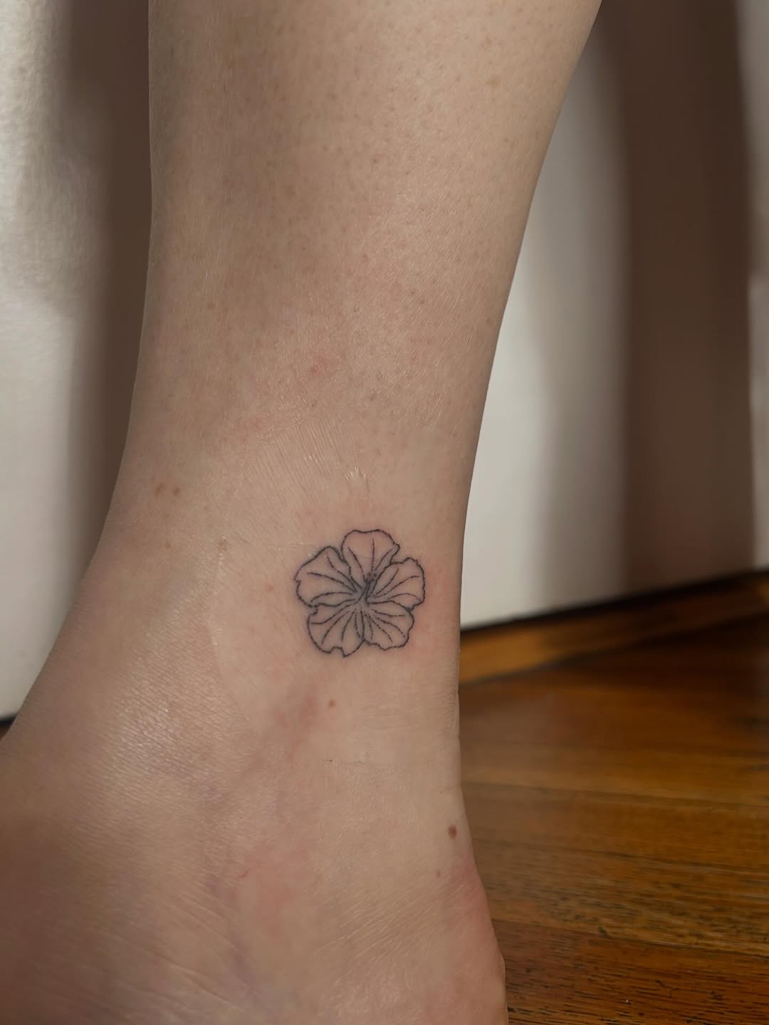 Hibiscus flower minimalist tattoo on the foot by Emma D