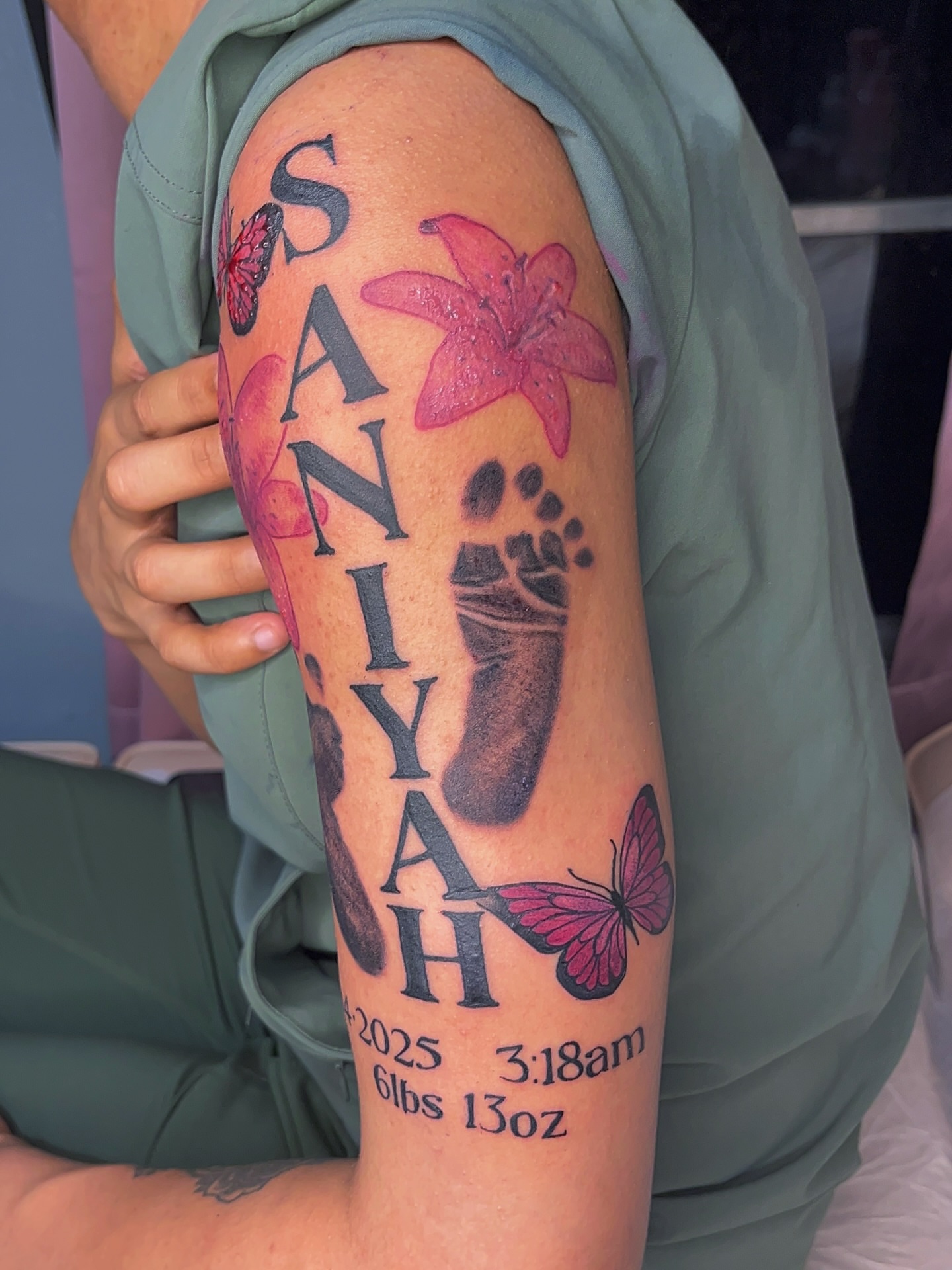 Baby name and footprint black and grey tattoo on the forearm by The inspo