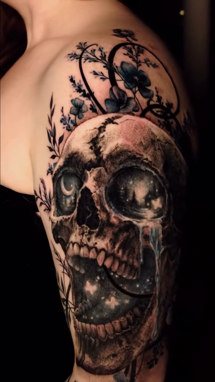 Skull with cosmic elements and flowers realism tattoo on the upper arm by Ohio Tattoo Artist - Tehya Maxwell, Springfield, Ohio