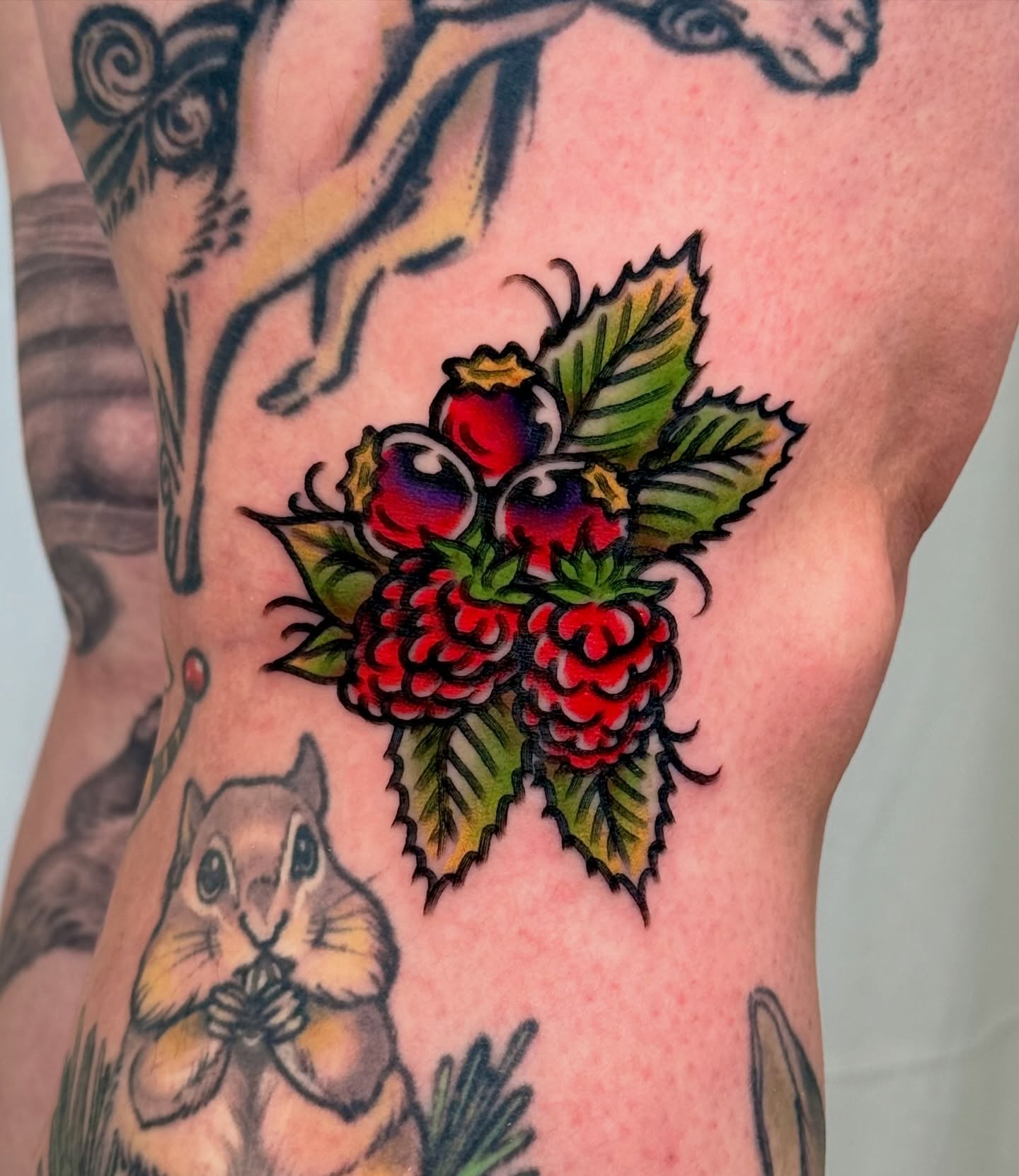 Raspberries American traditional tattoo on the upper arm by Tattooer Sancho 🇰🇷🇨🇦