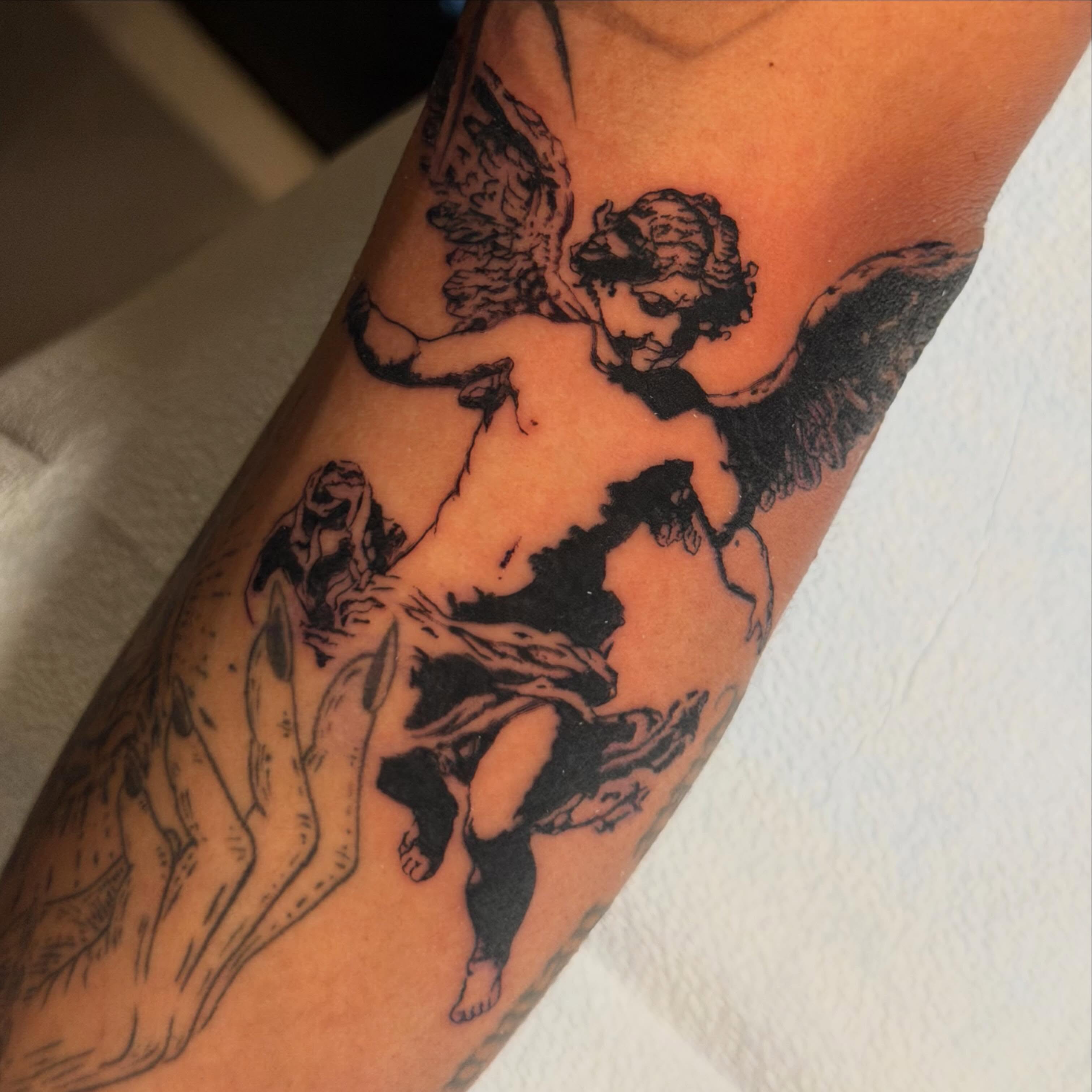 Cherub black and grey tattoo on the forearm by James Nelson