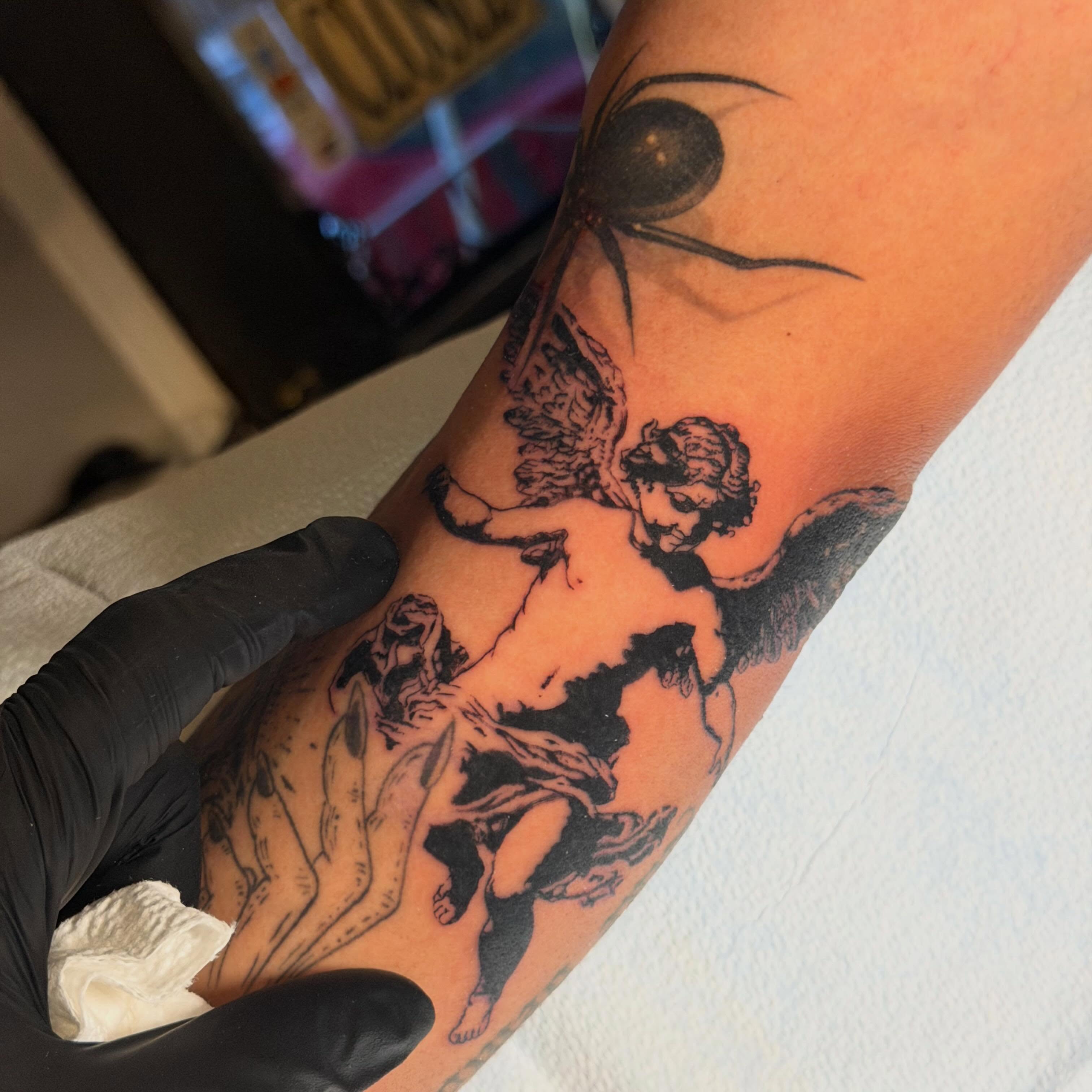 Cherub black and grey tattoo on the forearm by James Nelson