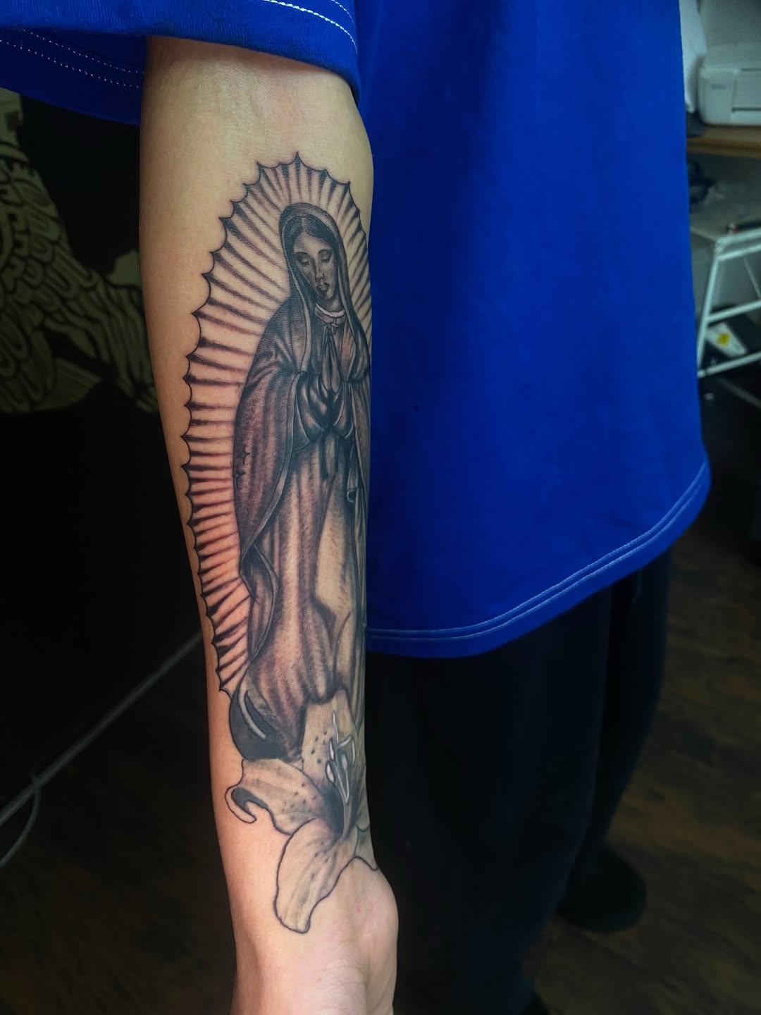 Virgin Mary and lily Chicano tattoo on the forearm by Irving Guzman