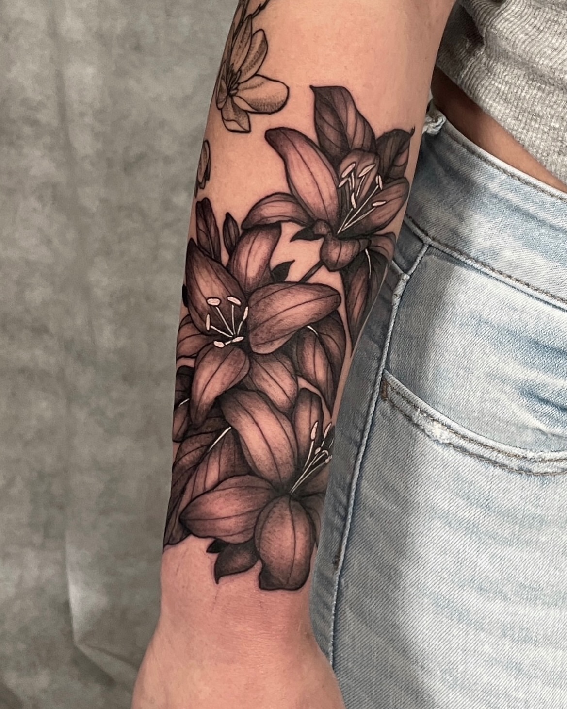 Lilies black and grey tattoo on the forearm by Austin Clark