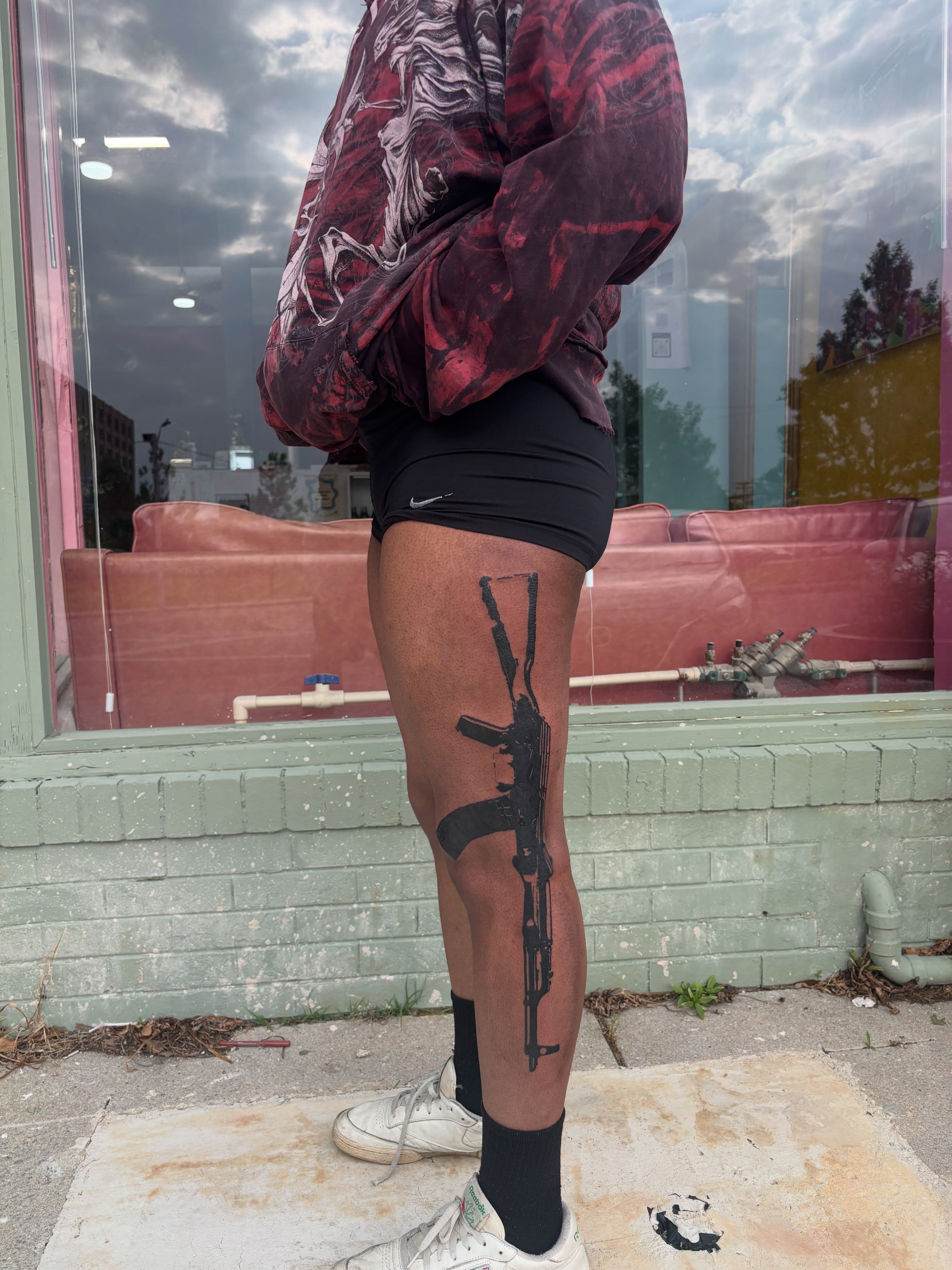 Machine gun black and grey tattoo on the leg by neal