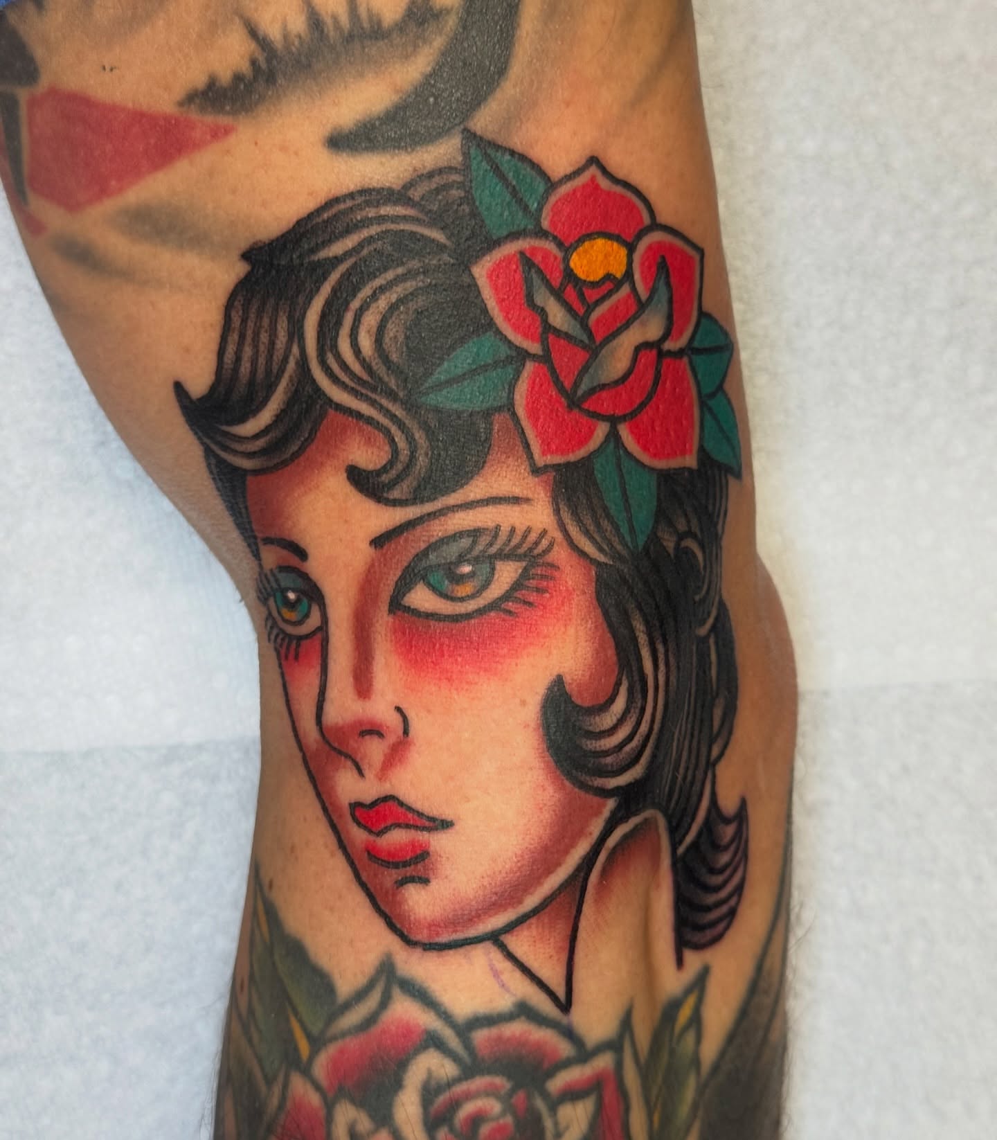 Woman with roses American traditional tattoo on the forearm by Kenneth Gibson