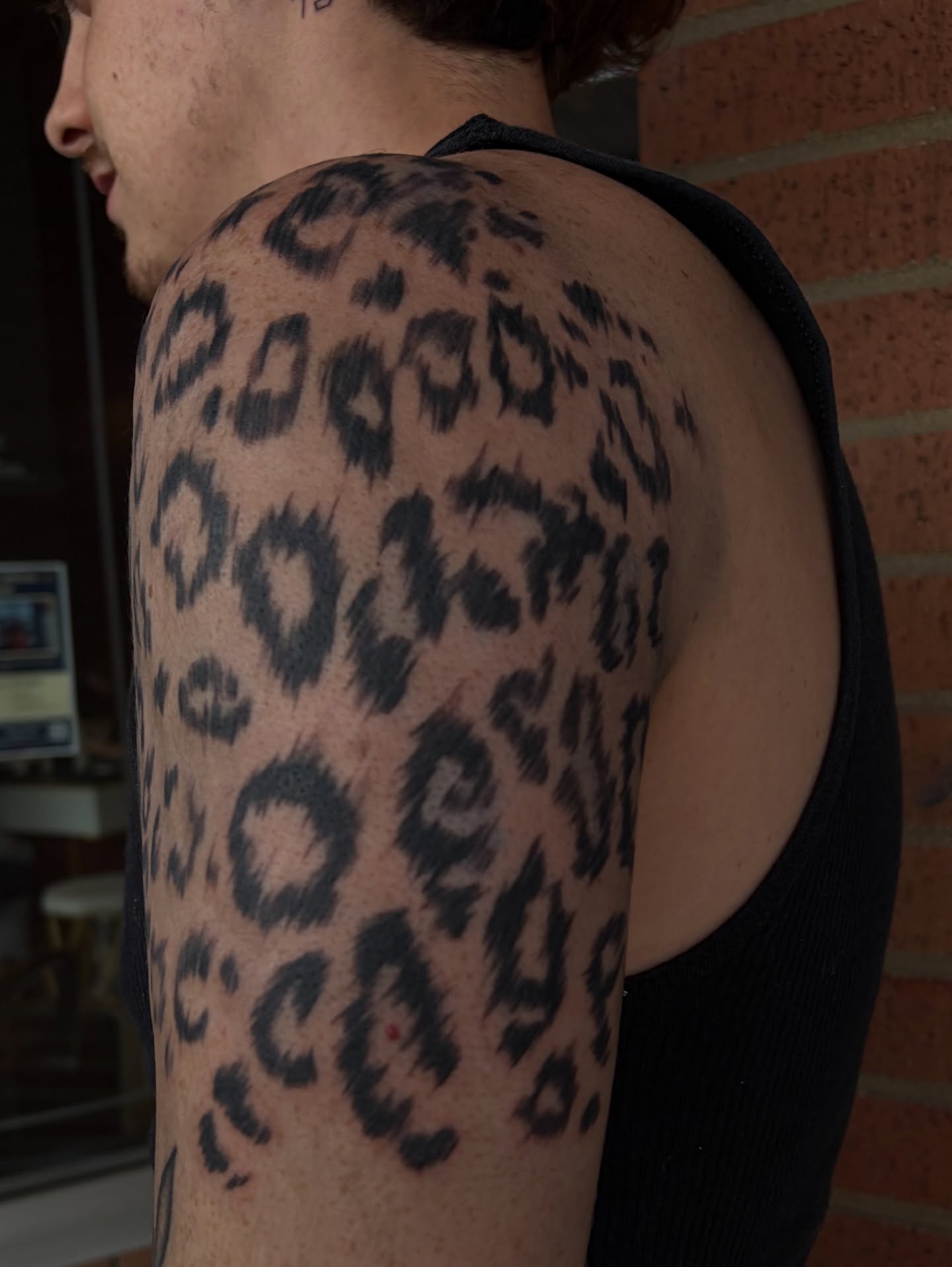 Leopard print black and grey tattoo on the shoulder by ⚜️Embodied Tattoo⚜️, Columbus, Ohio