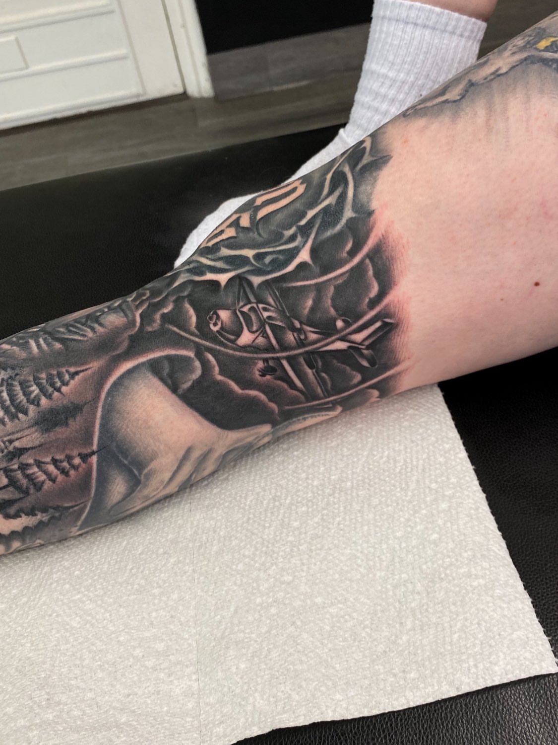 Ship sailing through clouds realism tattoo on the forearm by Kelan Mckenna