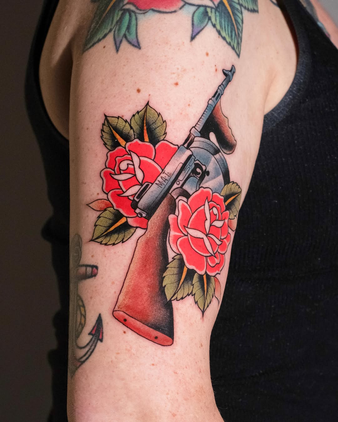 Machine gun and roses American traditional tattoo on the forearm by Danny Pando