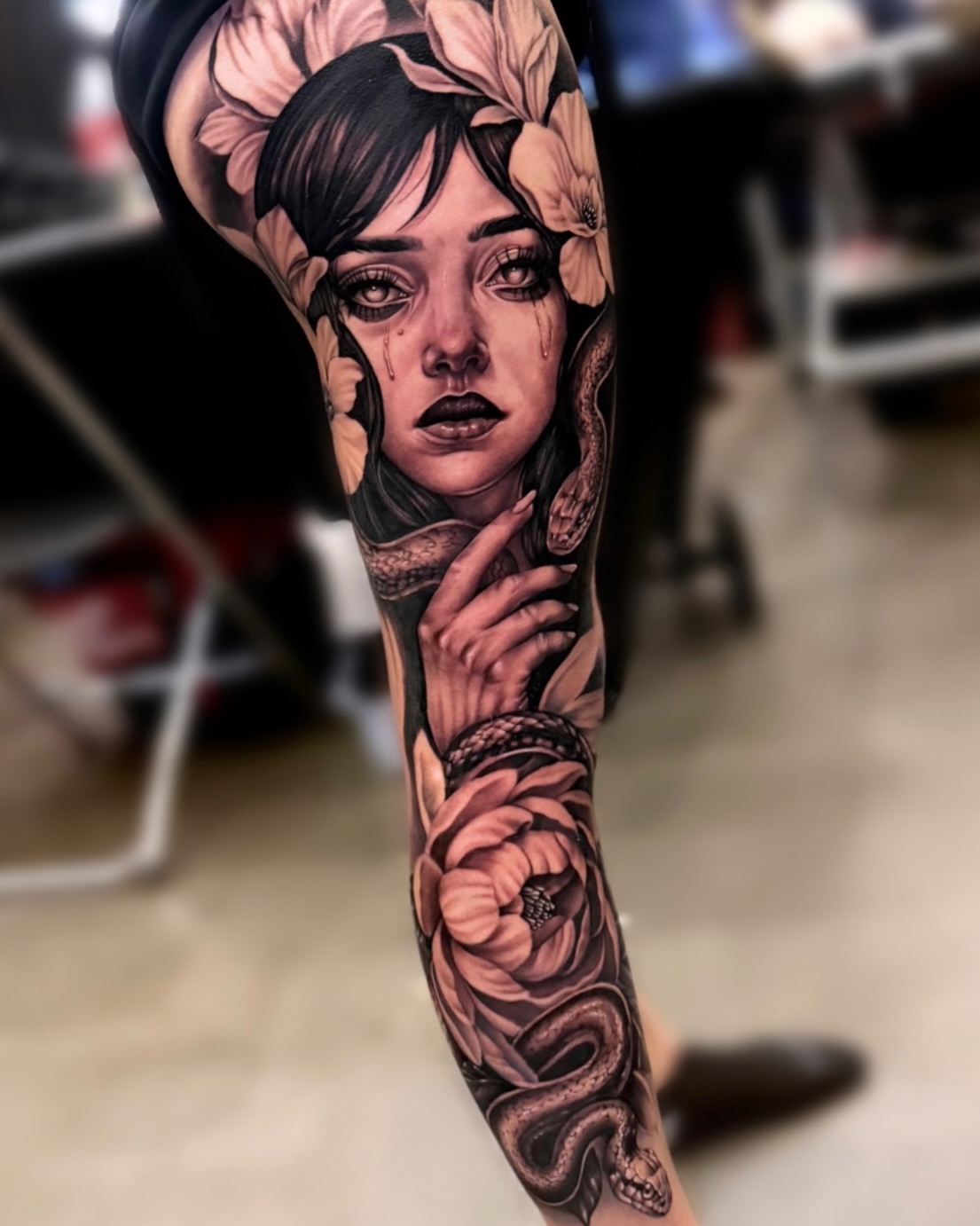 Woman with flowers realism tattoo on the forearm by Sebastian Calderon