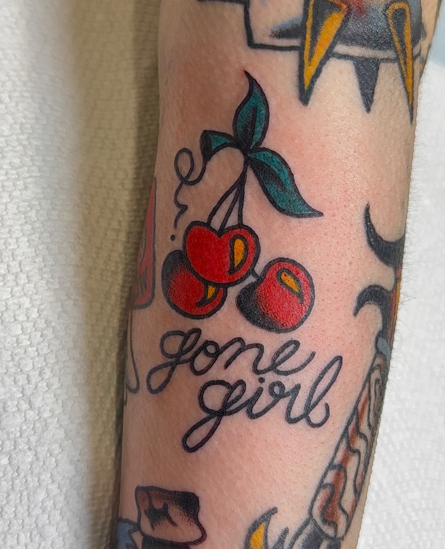 Cherries and 'gone girl' American traditional tattoo on the forearm by VAY