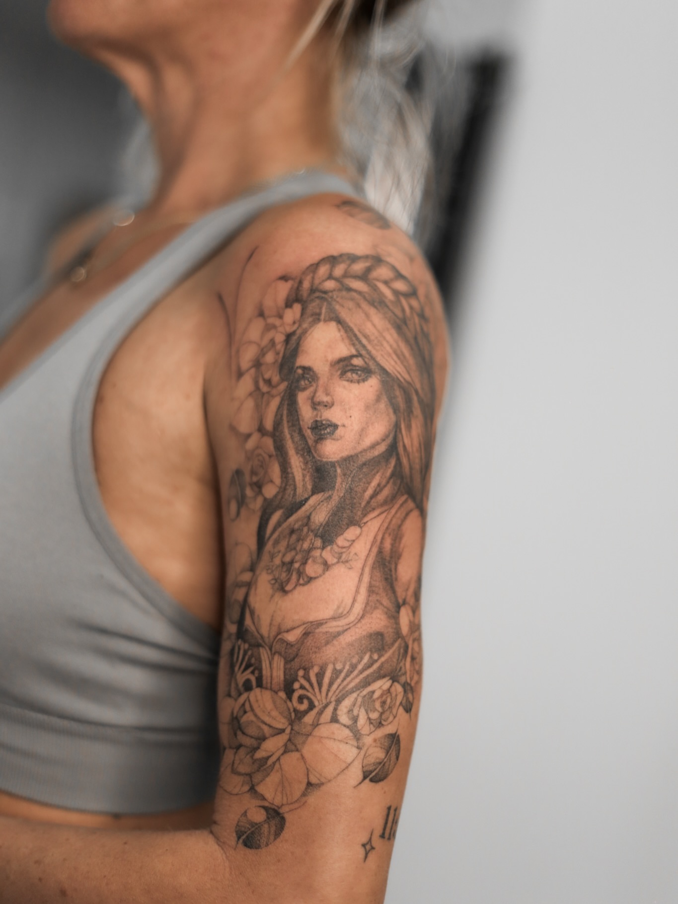Woman with flowers realism tattoo on the shoulder by Inna Petrova, Kitchener, Ontario