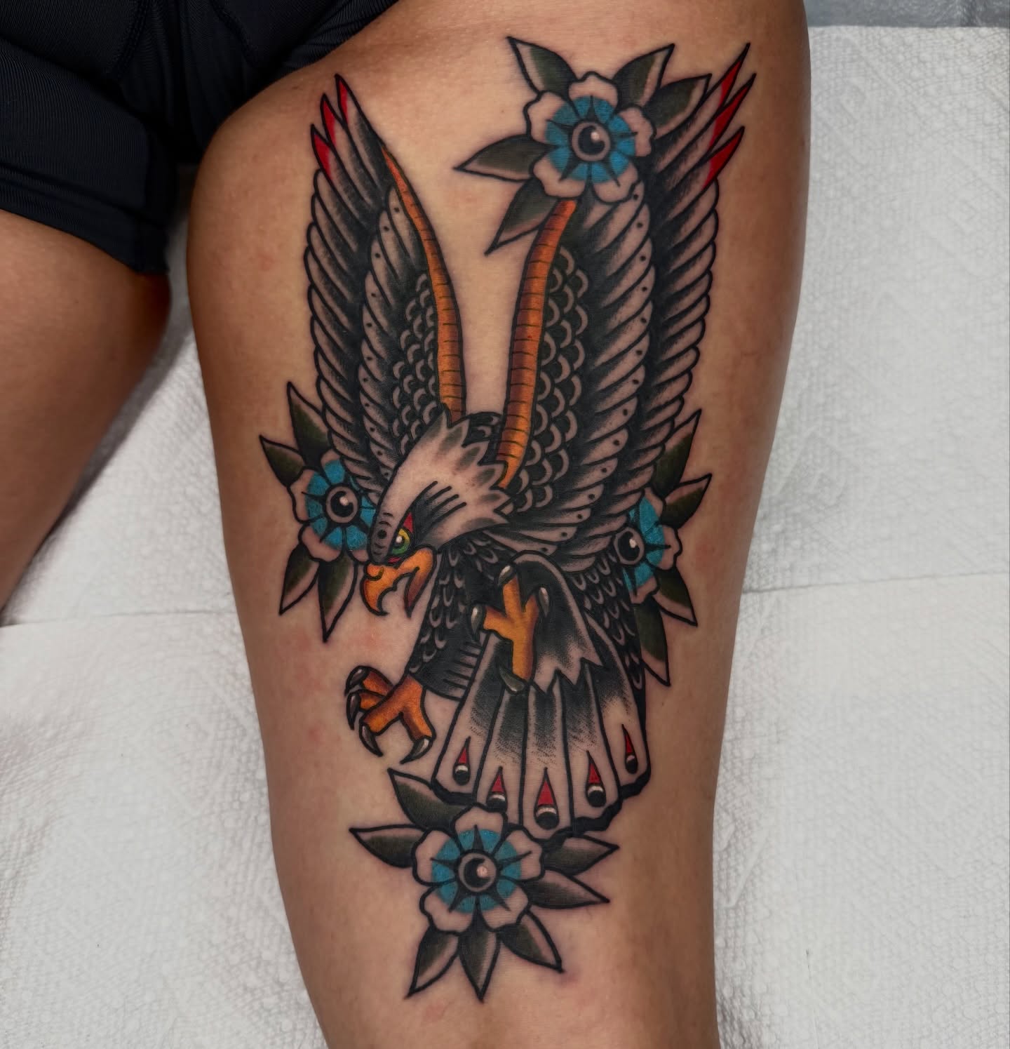 Eagle with flowers American traditional tattoo on the thigh by Noah Diffenderfer, Phoenix, Arizona