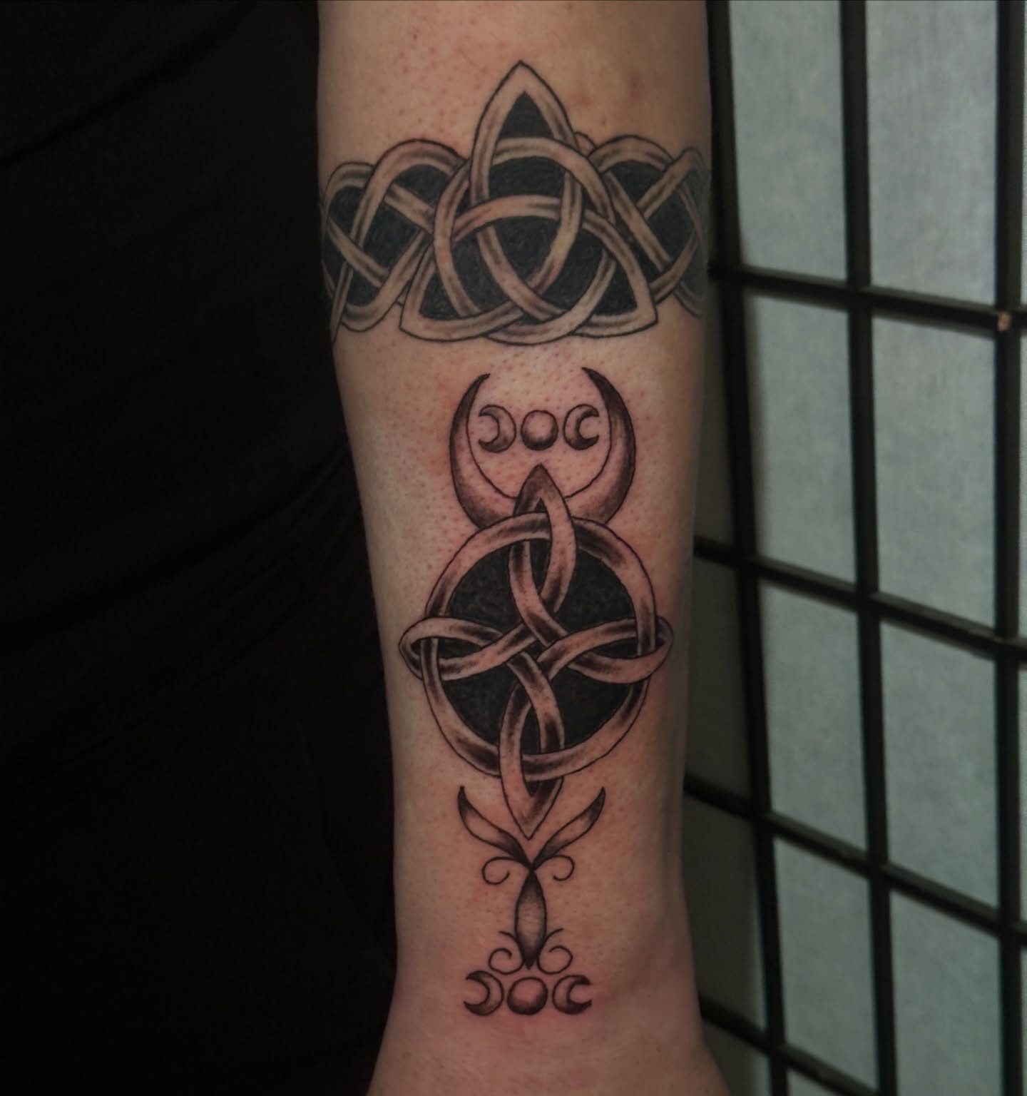 Trinity knot and moon phases geometric tattoo on the forearm by Chris Whittaker Tattoo Artist