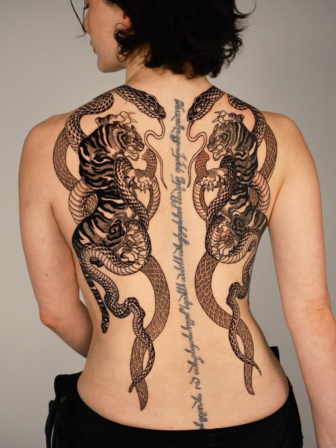 Tigers and snakes with script tribal tattoo on the back by Kubo