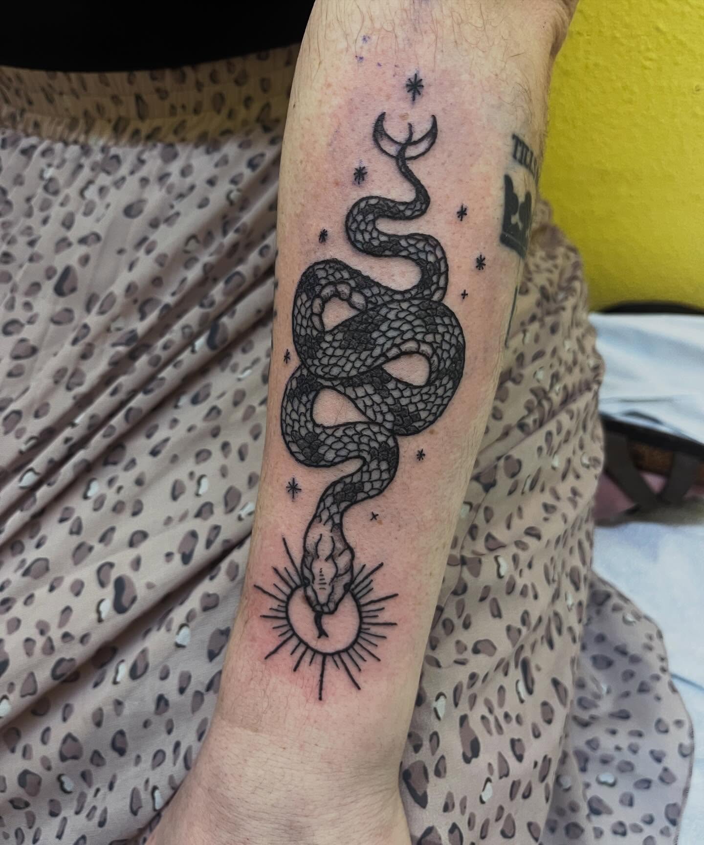 Snake black and grey tattoo on the forearm by Rafaela Lopez