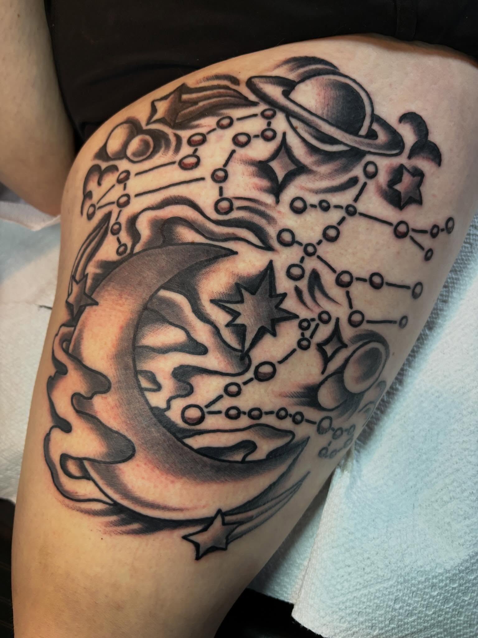 Constellations and celestial bodies black and grey tattoo on the thigh by Mitch Ashpaugh