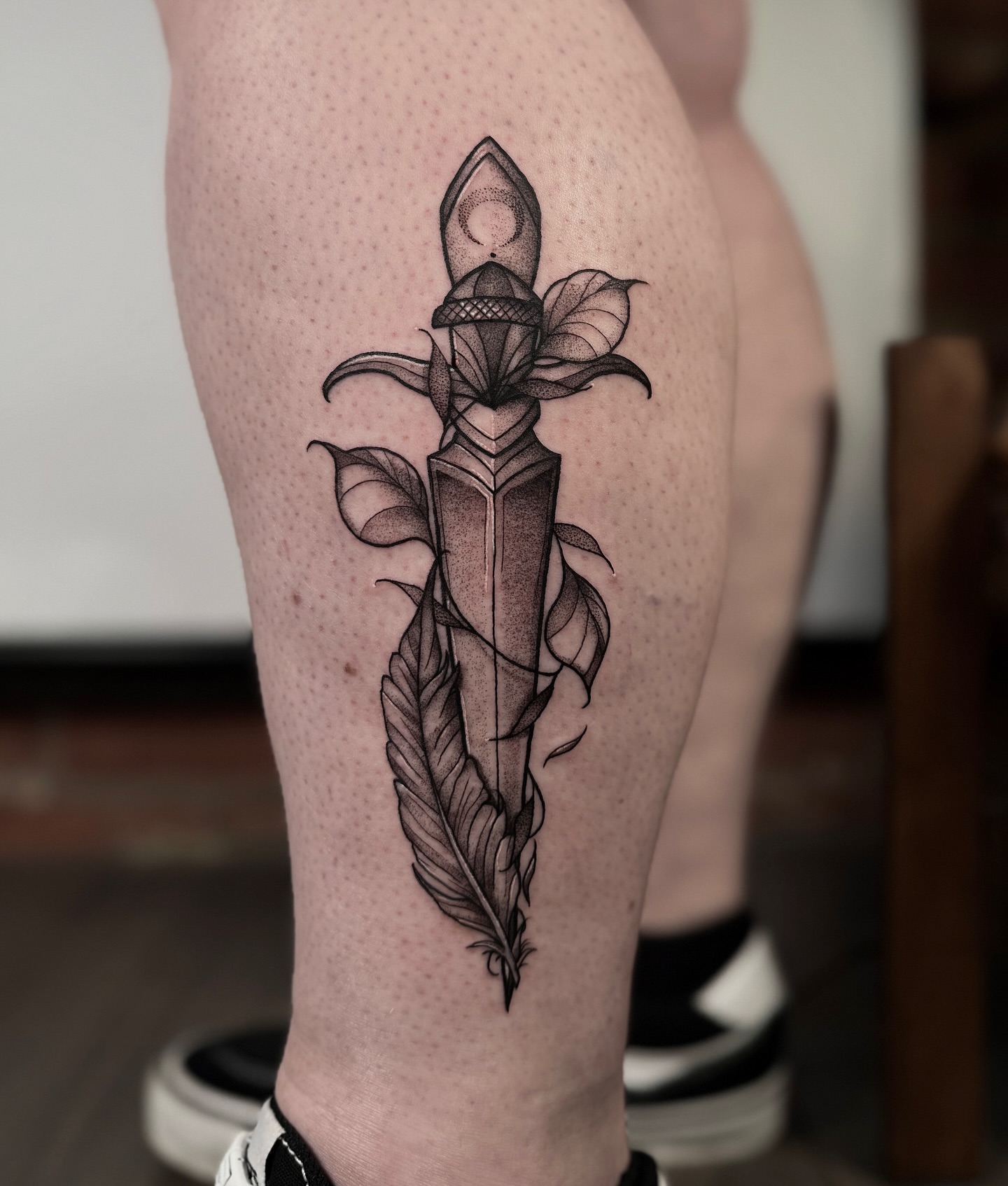 Knife with feathers dotwork tattoo on the thigh by Jessica Bloom