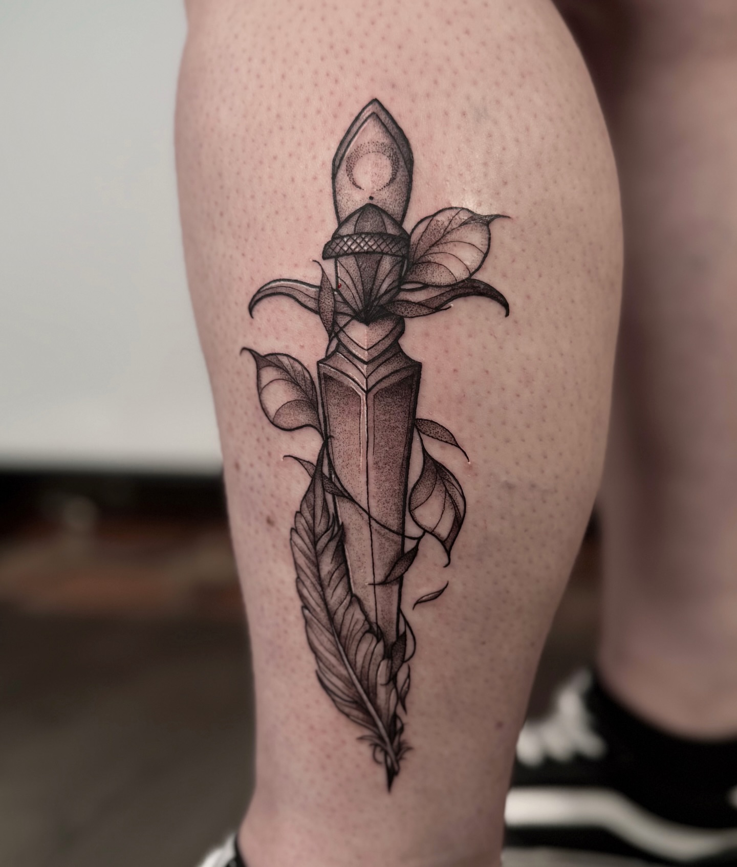 Knife and flower dotwork tattoo on the calf by Jessica Bloom