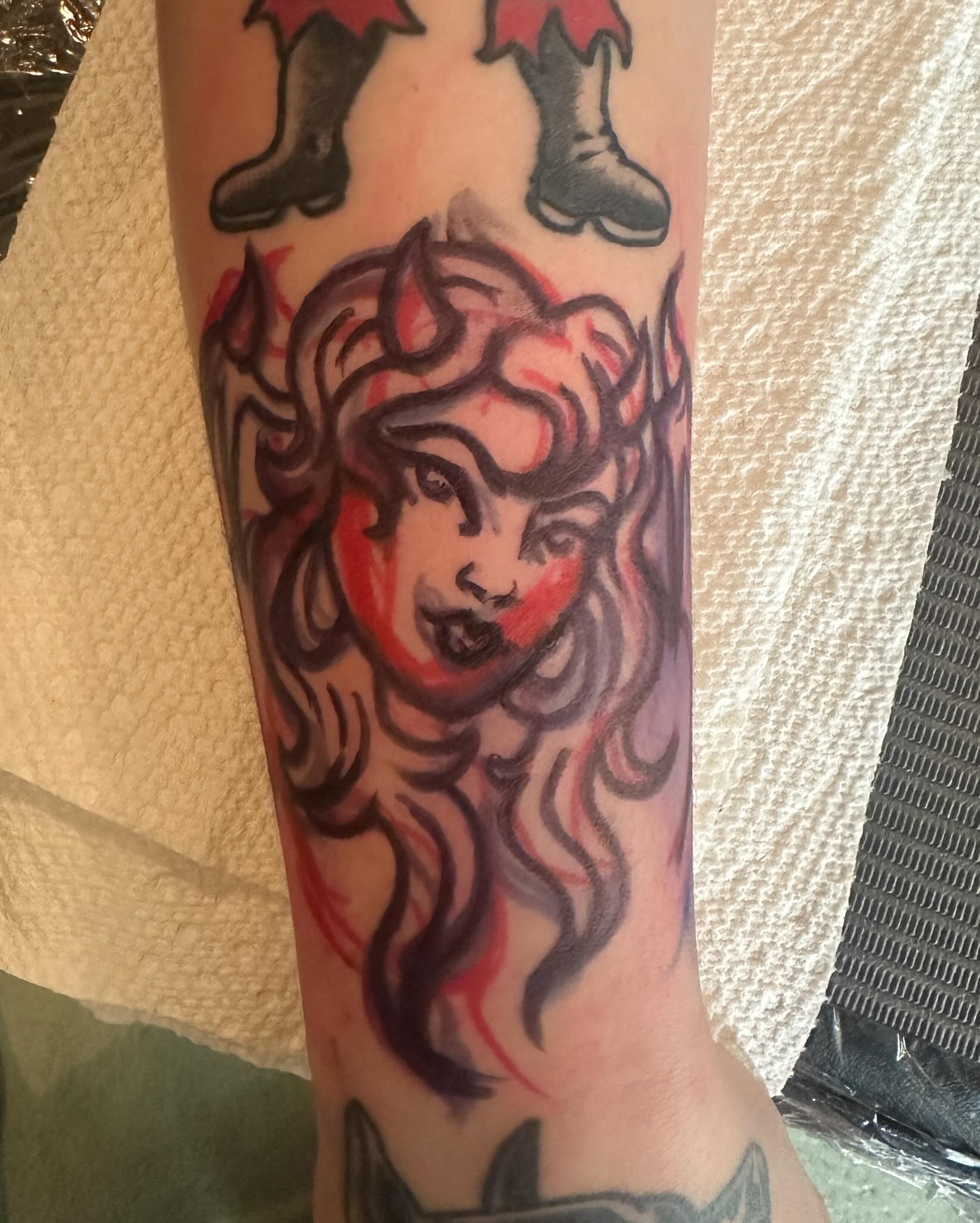 Woman with boots American traditional tattoo on the forearm by Stacey Colangelo