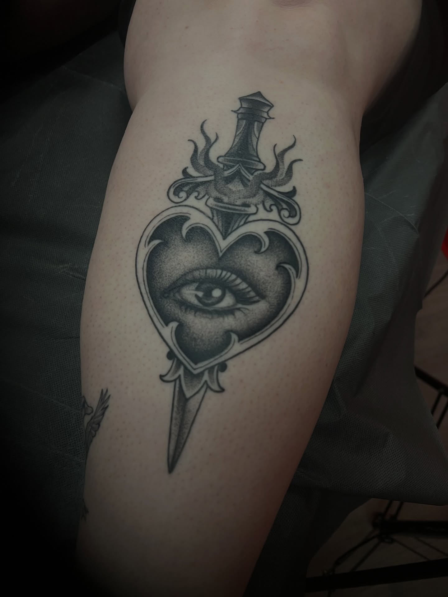 Heart with eye black and grey tattoo on the thigh by πΊπππππ π»πππππππ