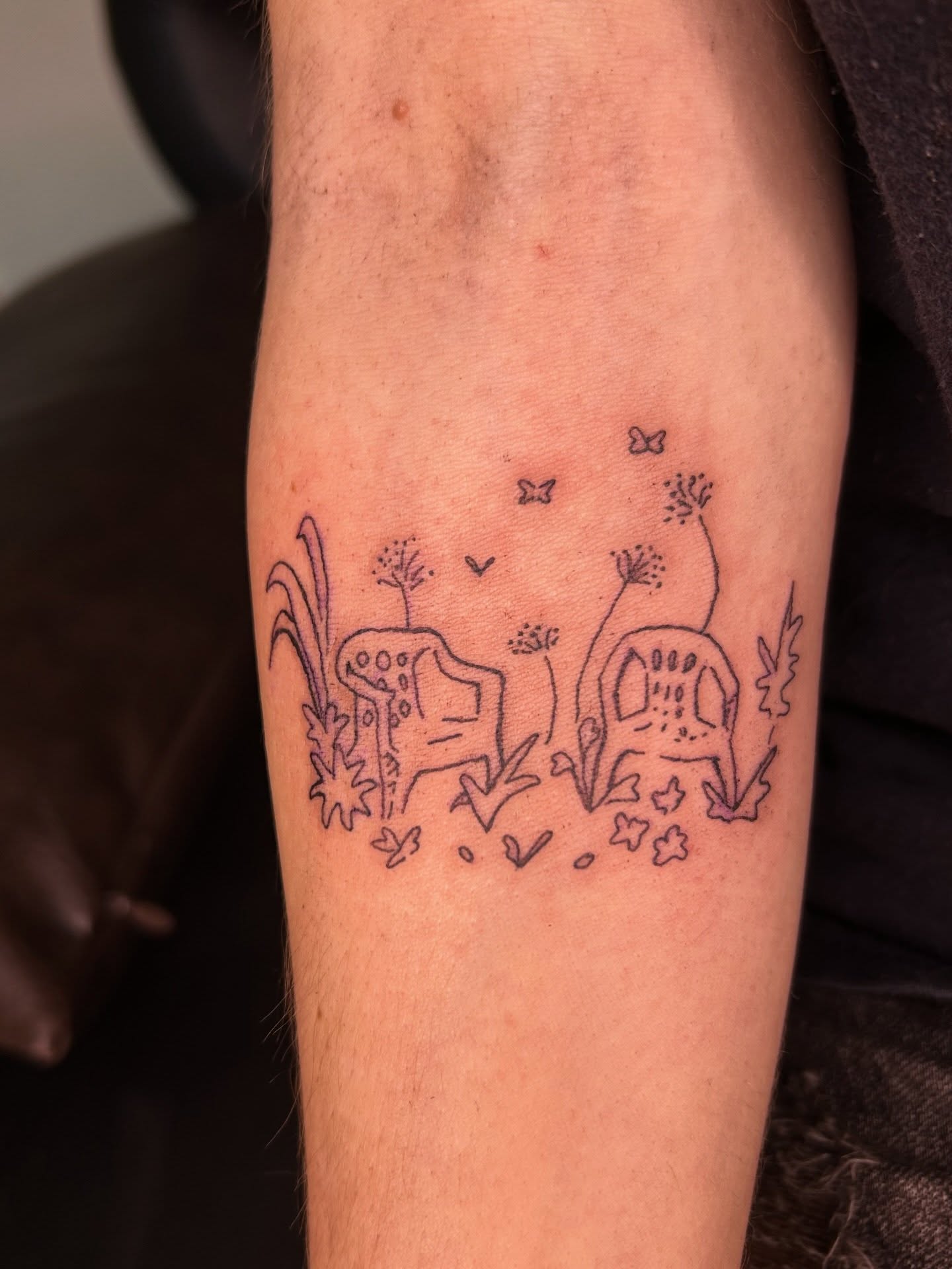 Skulls and dandelions black and grey tattoo on the forearm by Mattie Robinson