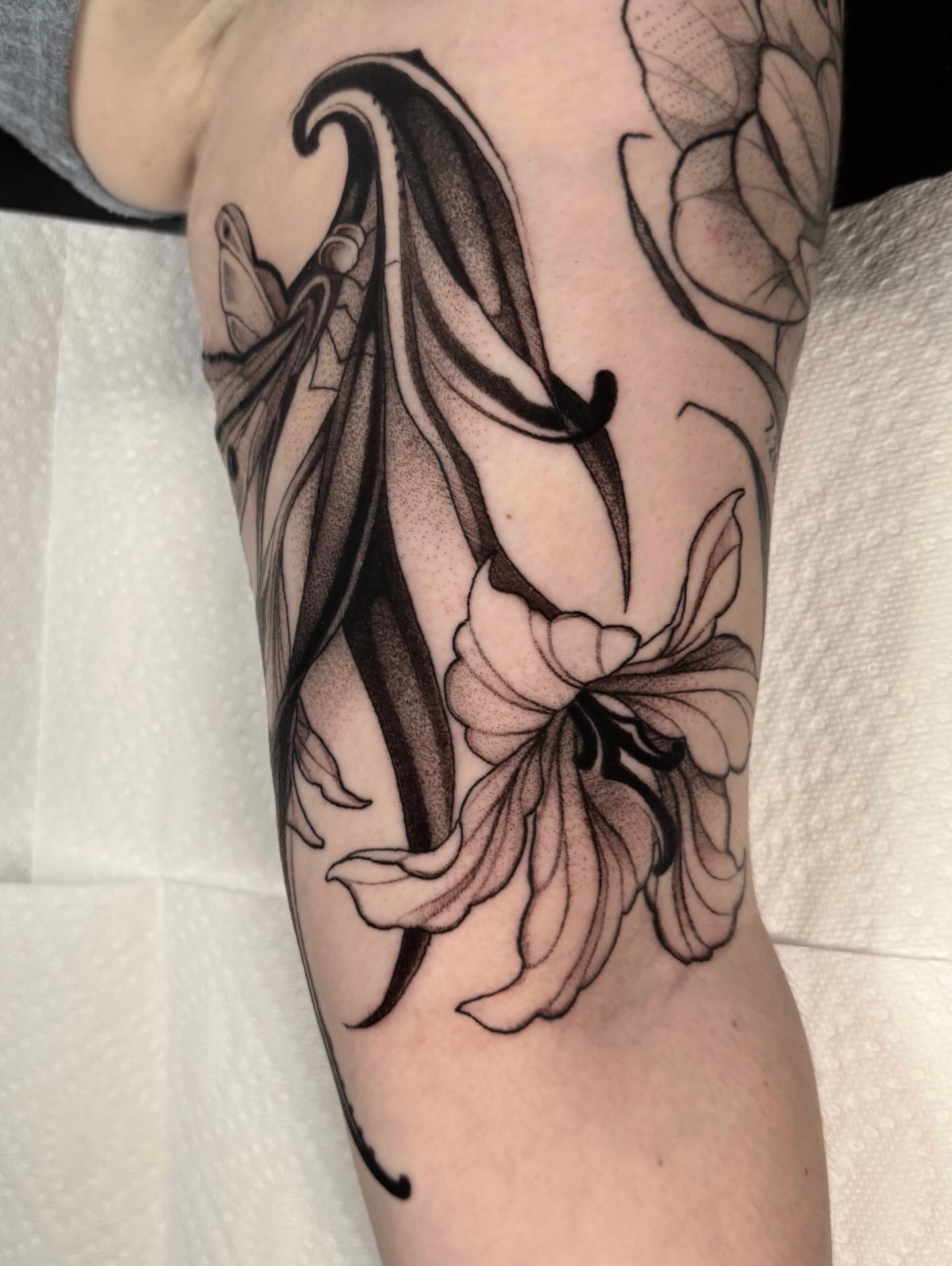 Lily and wings dotwork tattoo on the forearm by jada