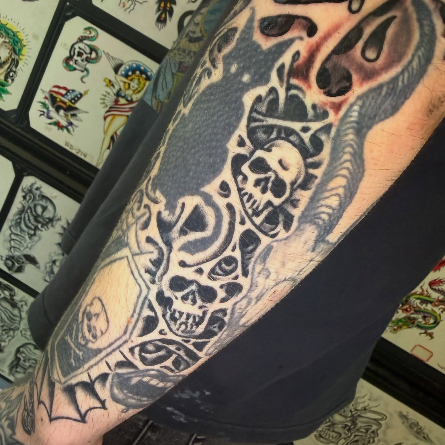 Skulls and flames geometric tattoo on the forearm by Mike Dunn