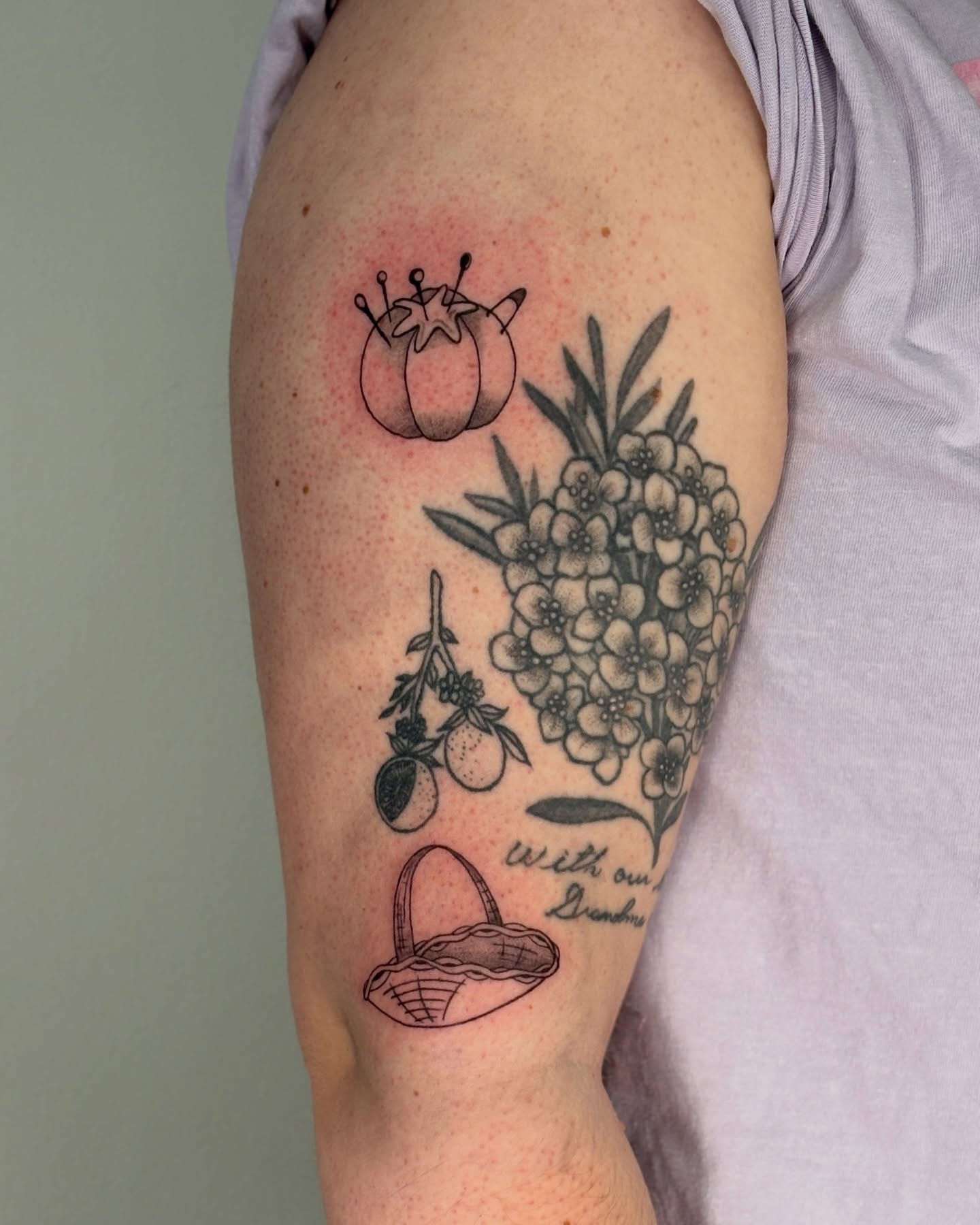 Fruit and flowers black and grey tattoo on the forearm by Maddie
