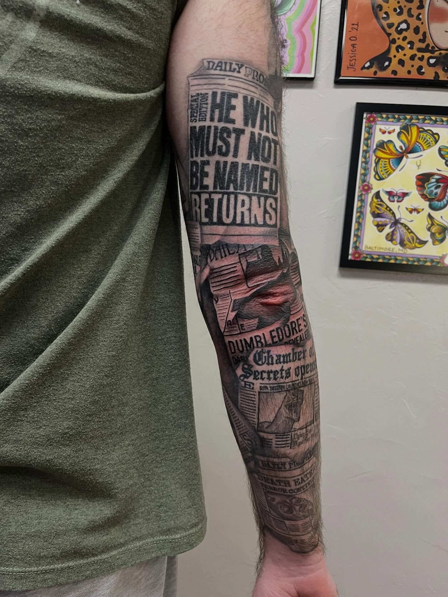 Newspaper headline black and grey tattoo on the forearm by Lauren Bumgardner