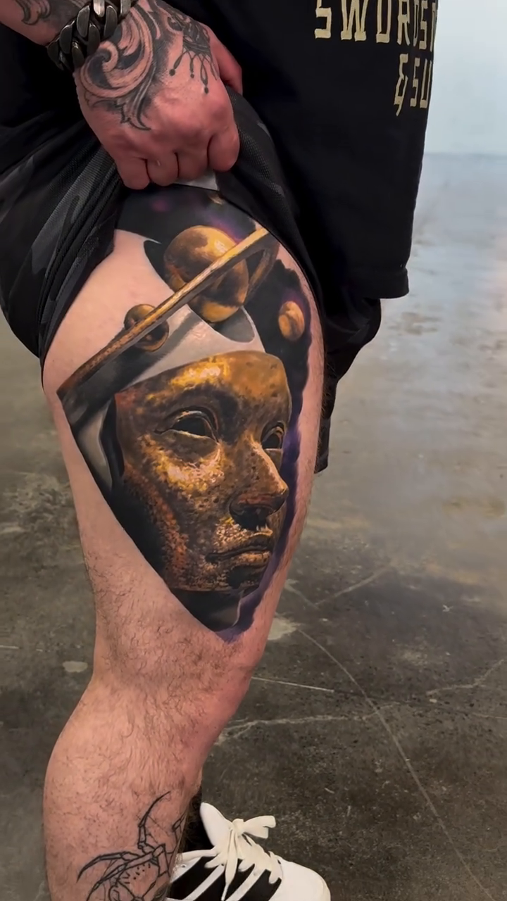 Golden mask with abstract elements surrealism tattoo on the leg by Jacob Sheffield, Grand Junction, Colorado