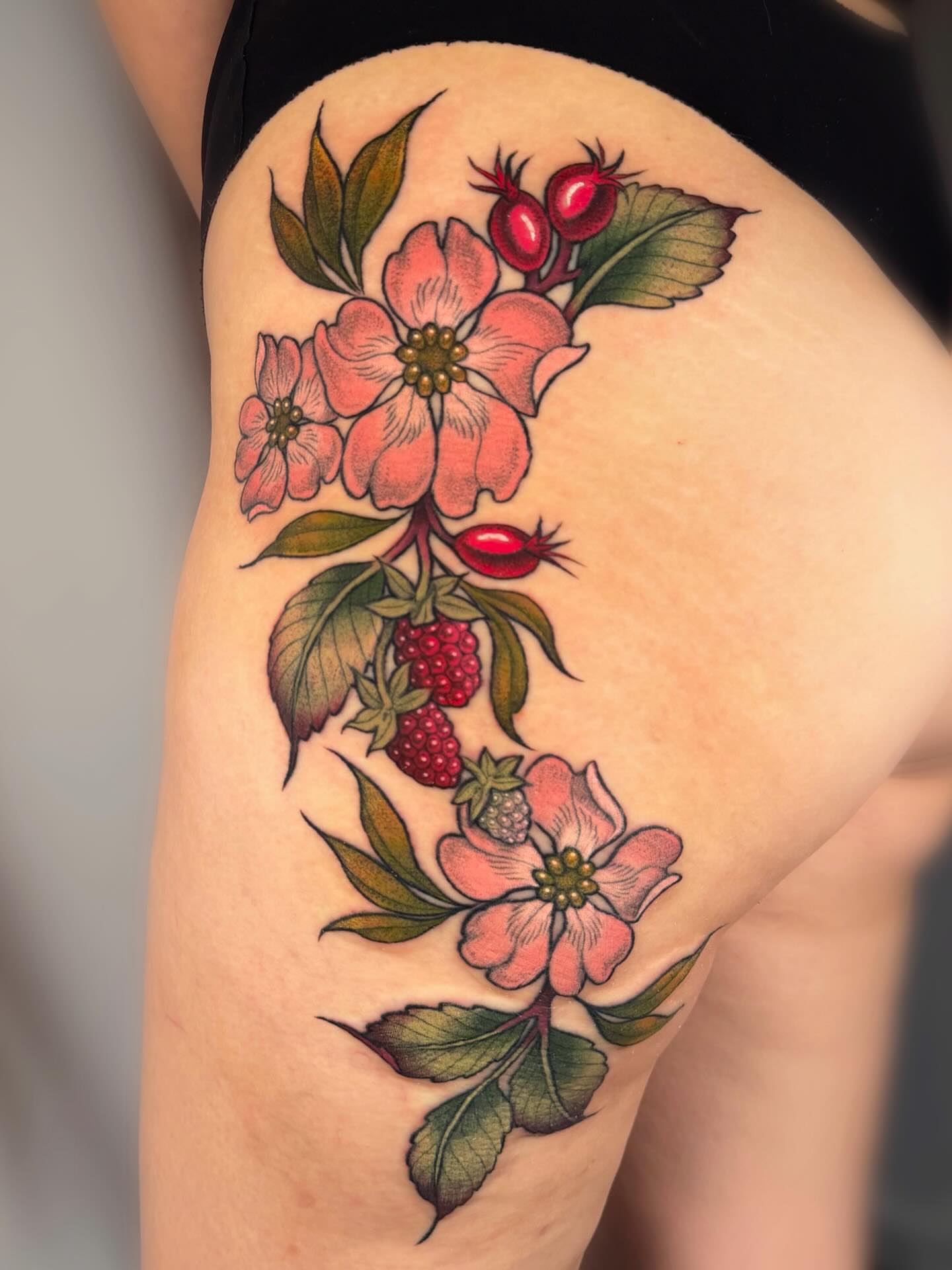 Dogwood flowers and berries American traditional tattoo on the thigh by leanna patterson, Ruston, Louisiana