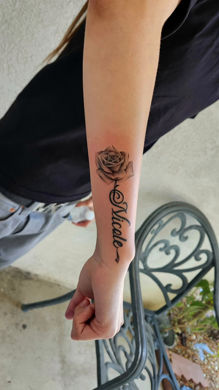 Rose with name lettering tattoo on the forearm by @youxg_guxxz