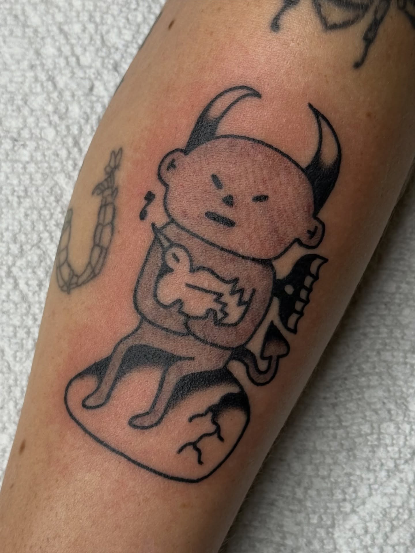 Baby demon black and grey tattoo on the forearm by Roman