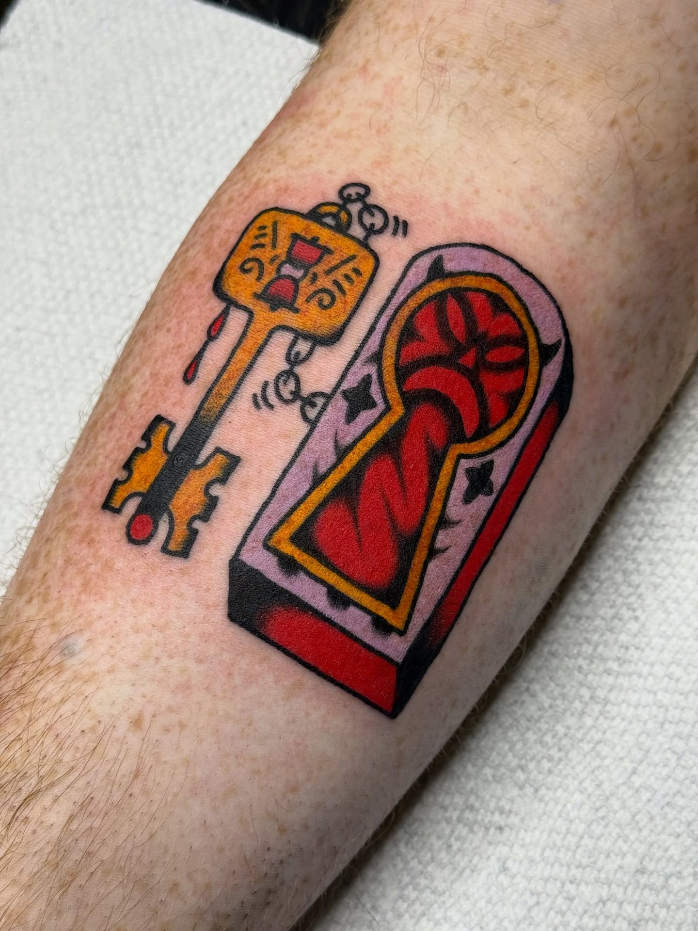 Key and lock American traditional tattoo on the forearm by Roman