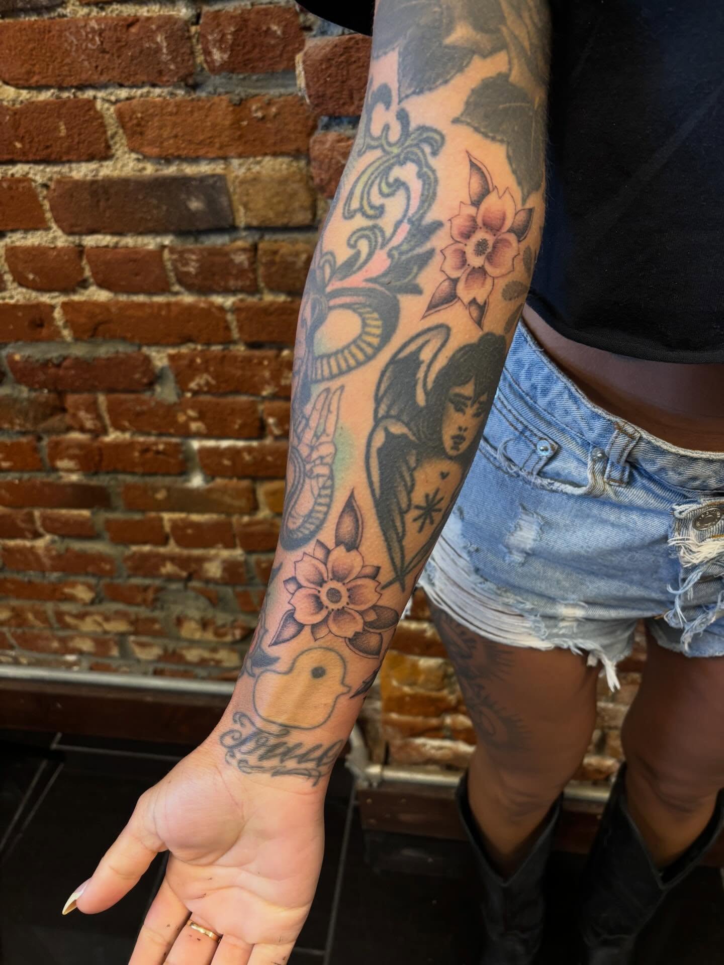 Angel with flowers American traditional tattoo on the forearm by Alyssa L'Heureux🕴🏼, Los Angeles, California