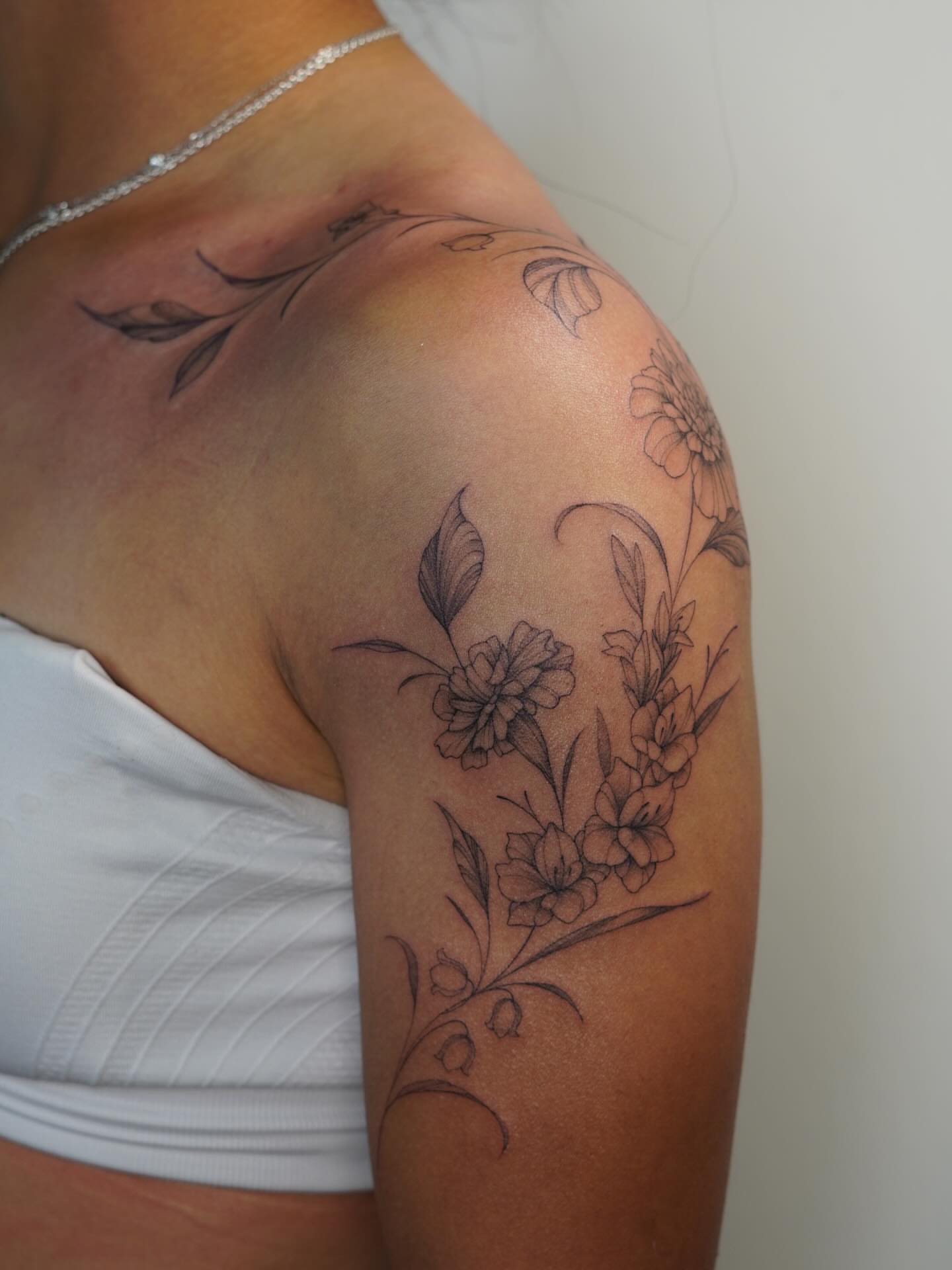 Floral bouquet black and grey tattoo on the shoulder by Danae Andino