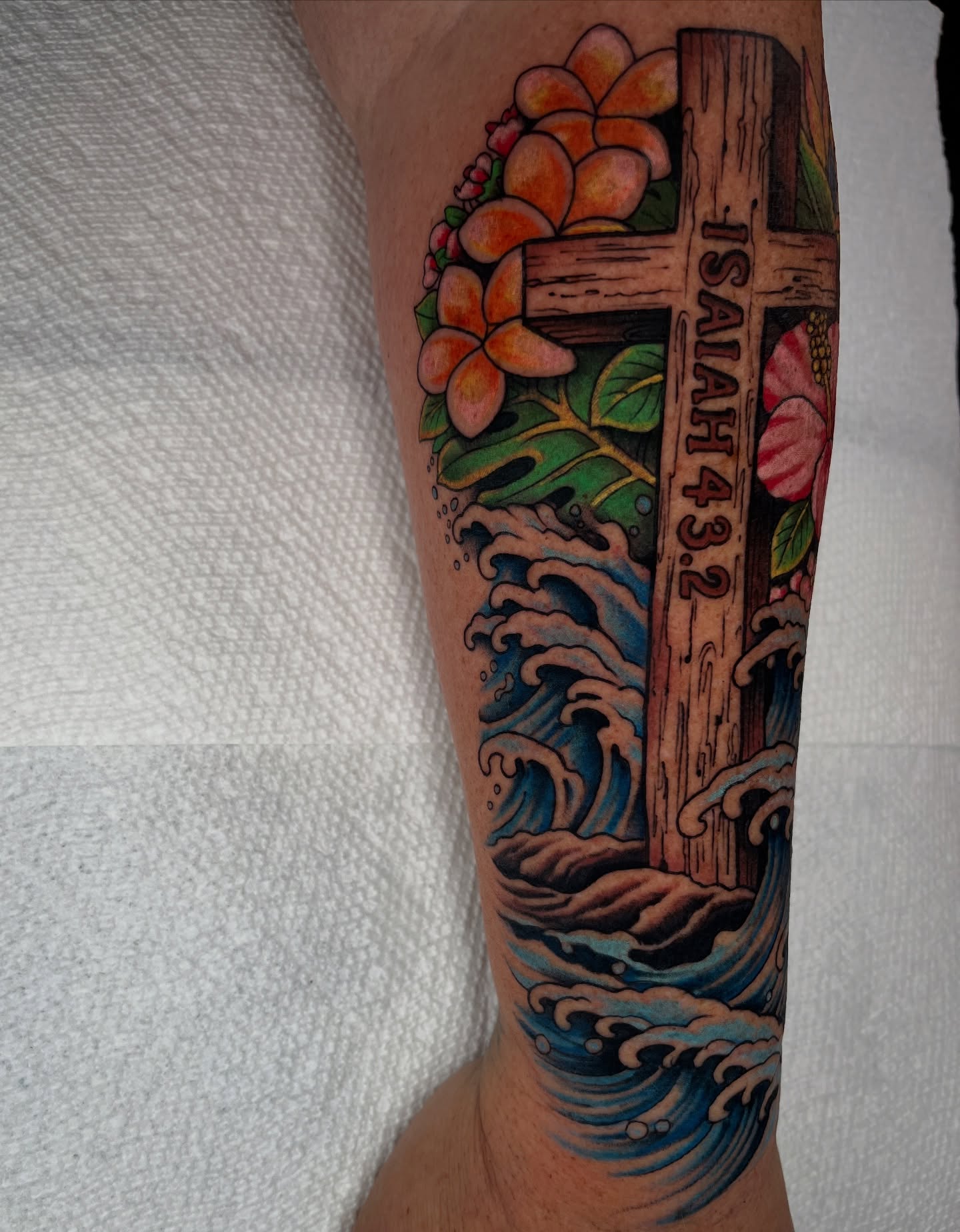 Cross and flowers American traditional tattoo on the forearm by Jordan Hunt