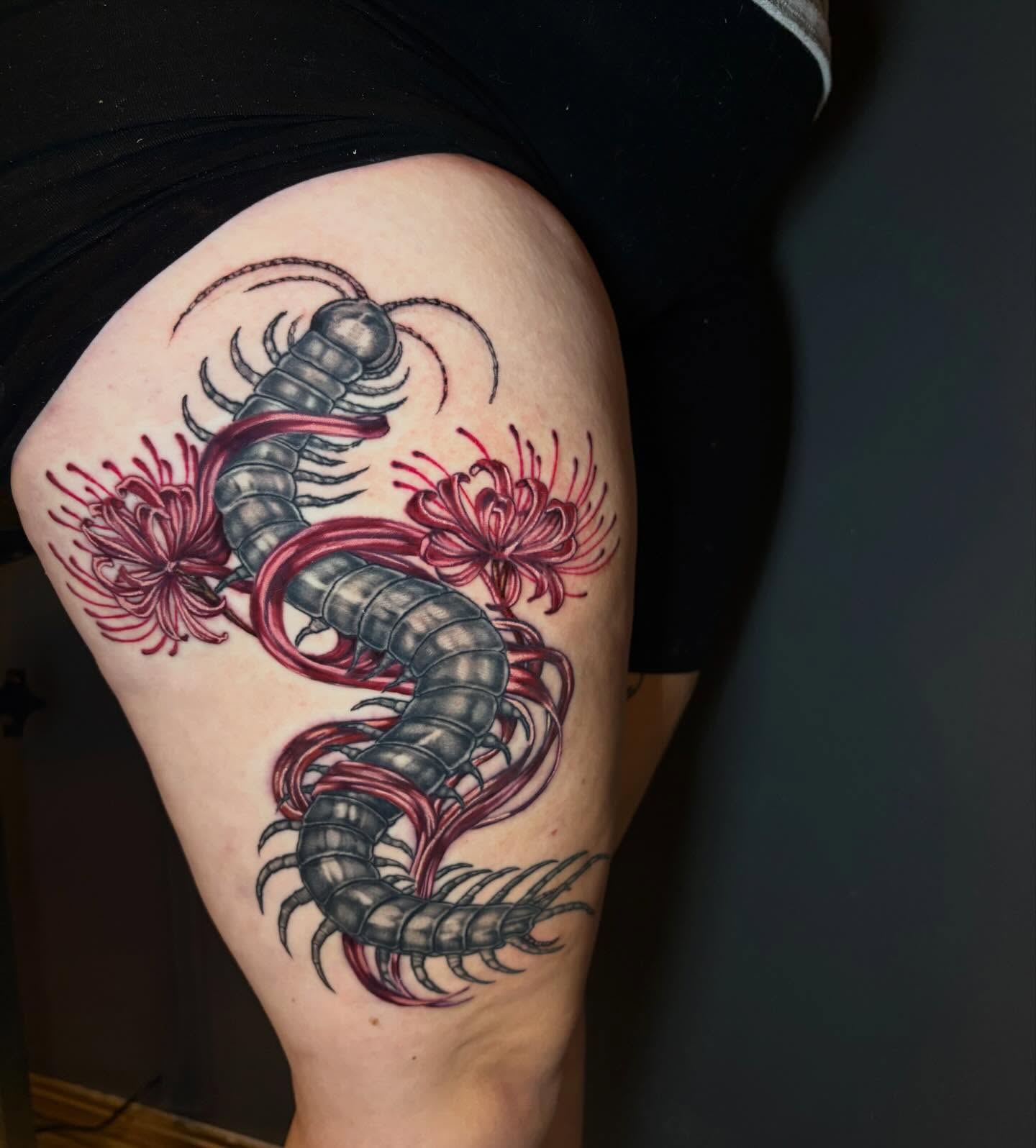 Centipede and flowers realism tattoo on the thigh by Rachel Sellers