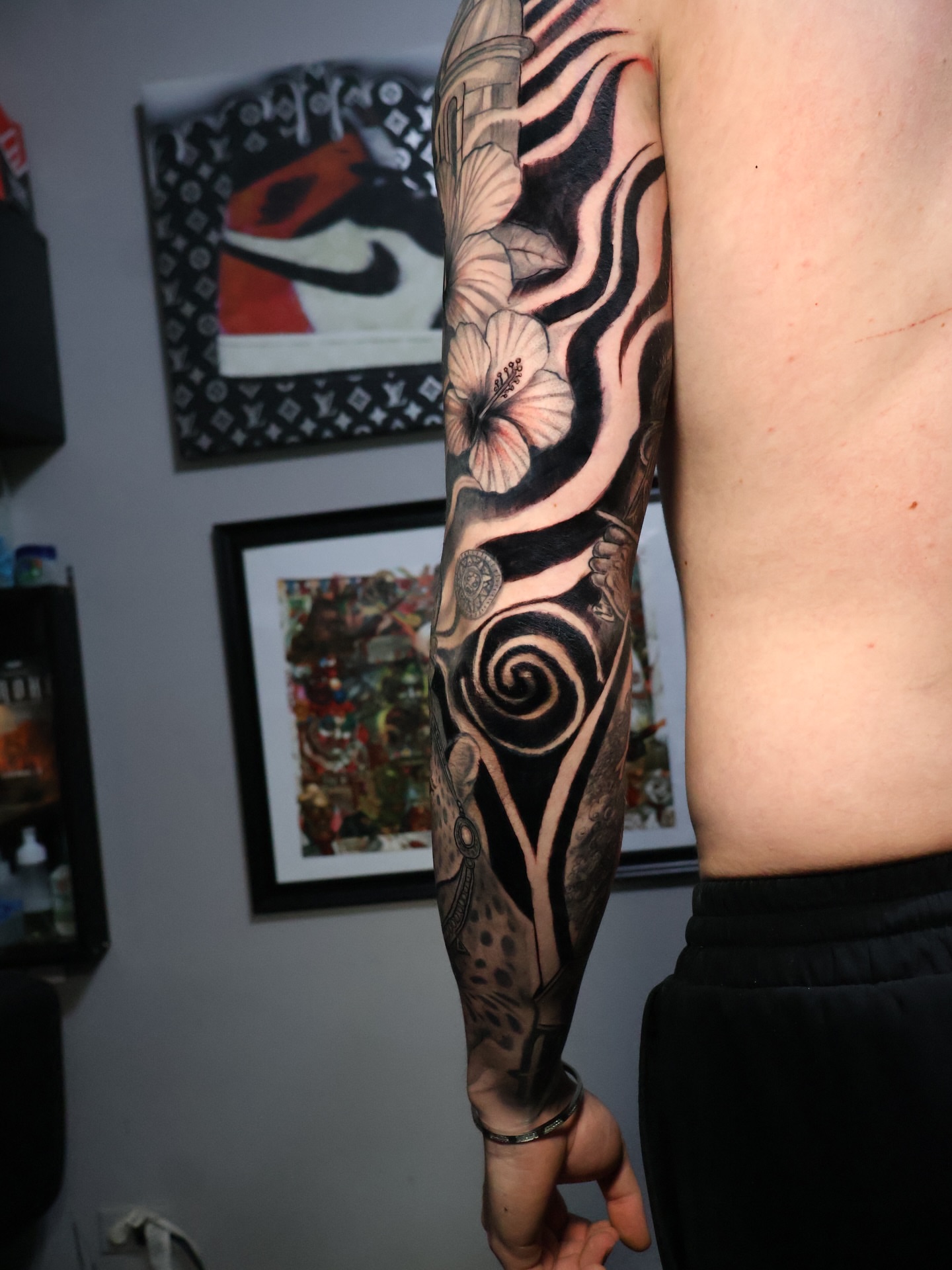Floral swirls geometric tattoo on the upper arm by German Patiño.